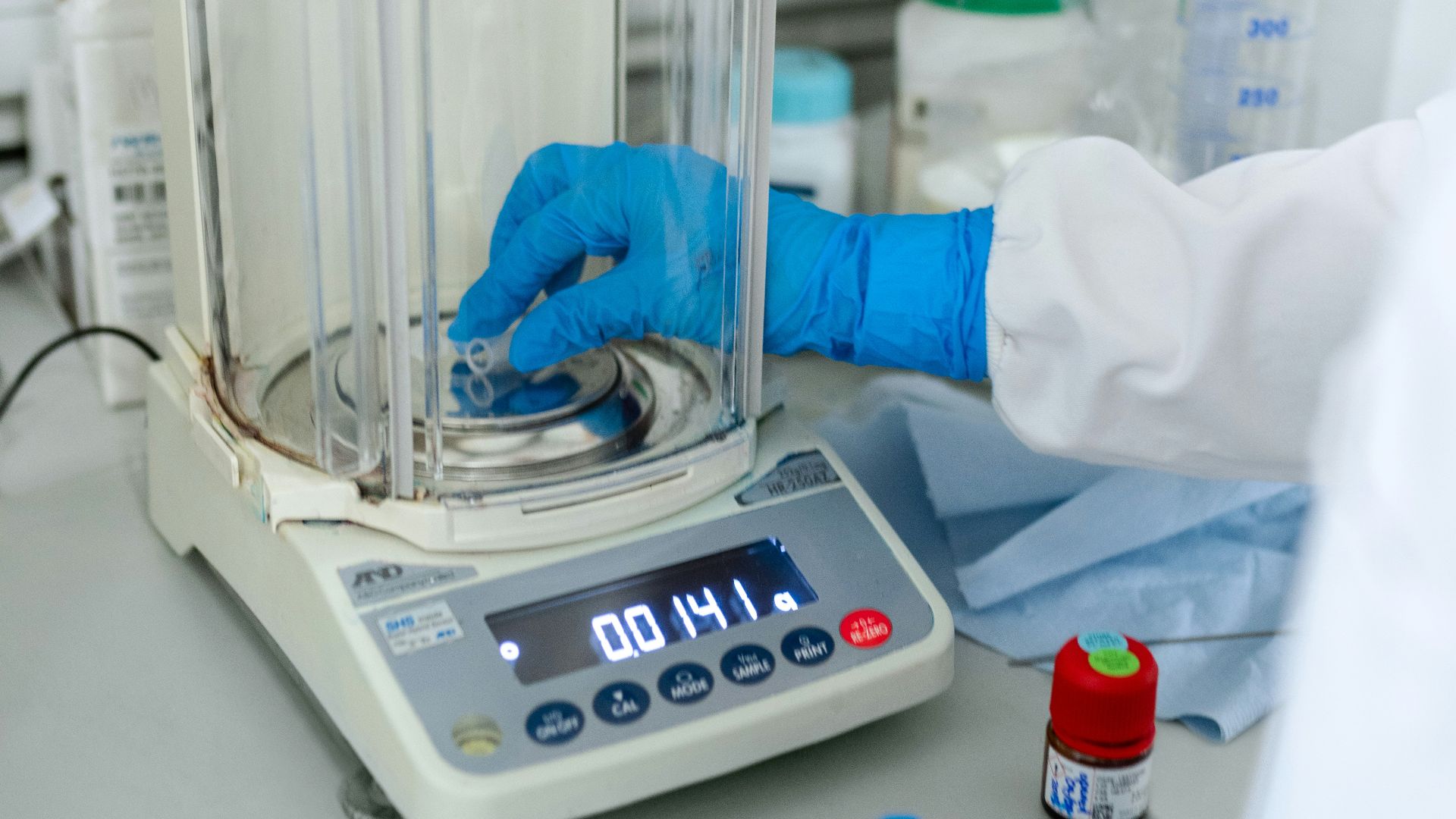 person in white long sleeve shirt standing beside blue and white hospital bed