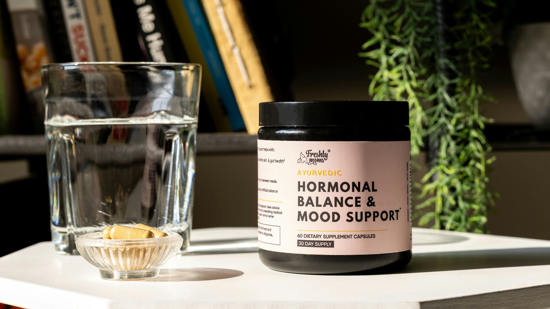 a glass of water next to a jar of balance and mood support