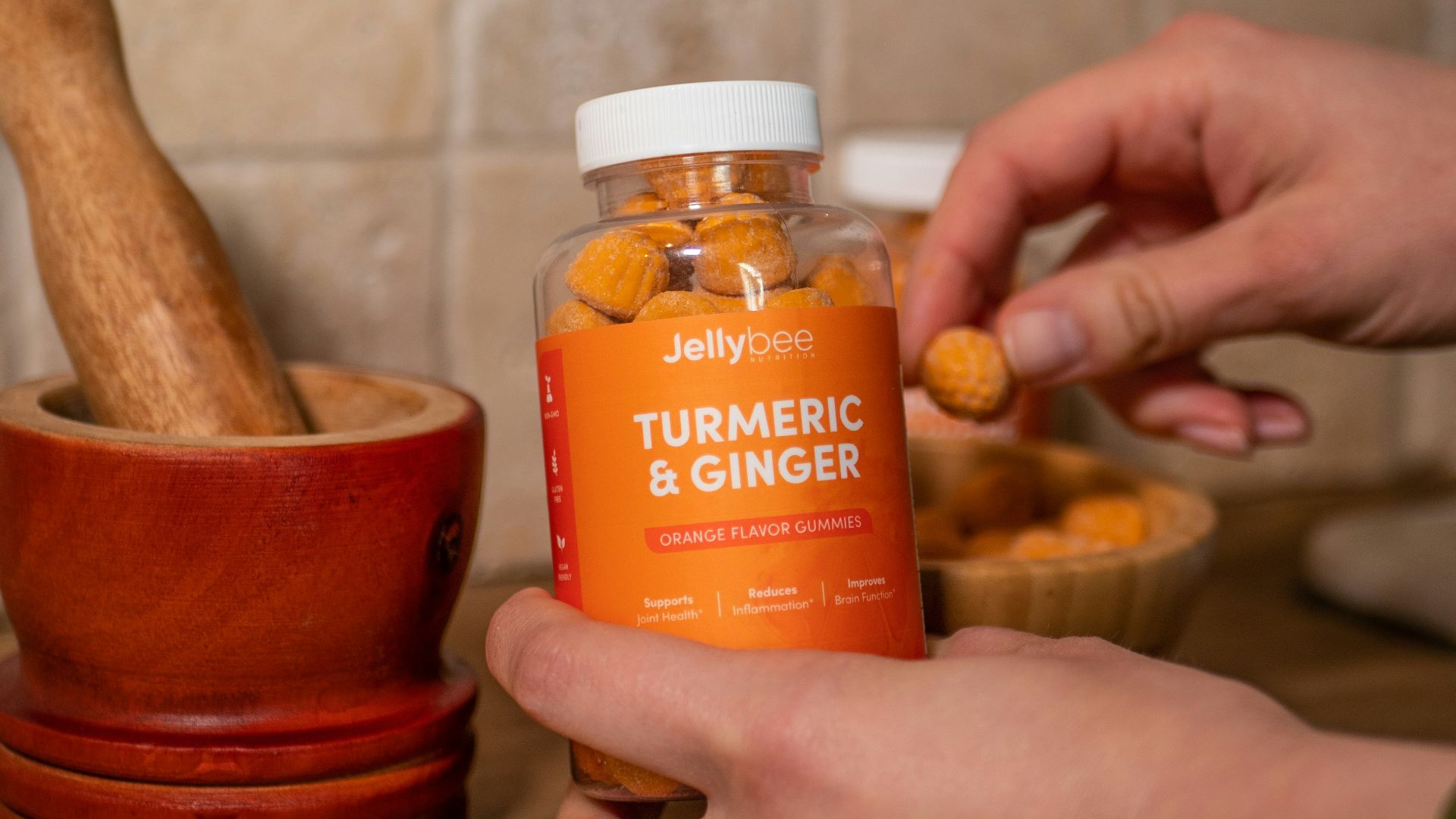 person holding orange plastic bottle