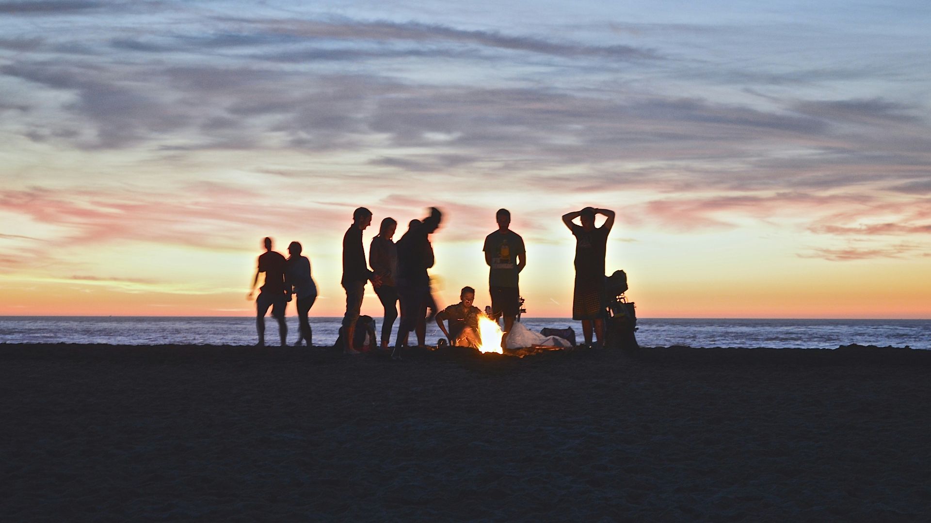 group of people setting up campfire