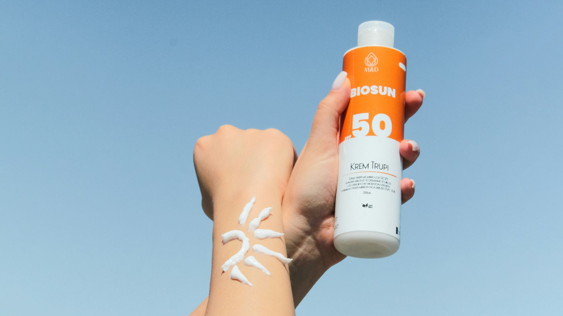 a person holding a bottle of sunscreen in their hand