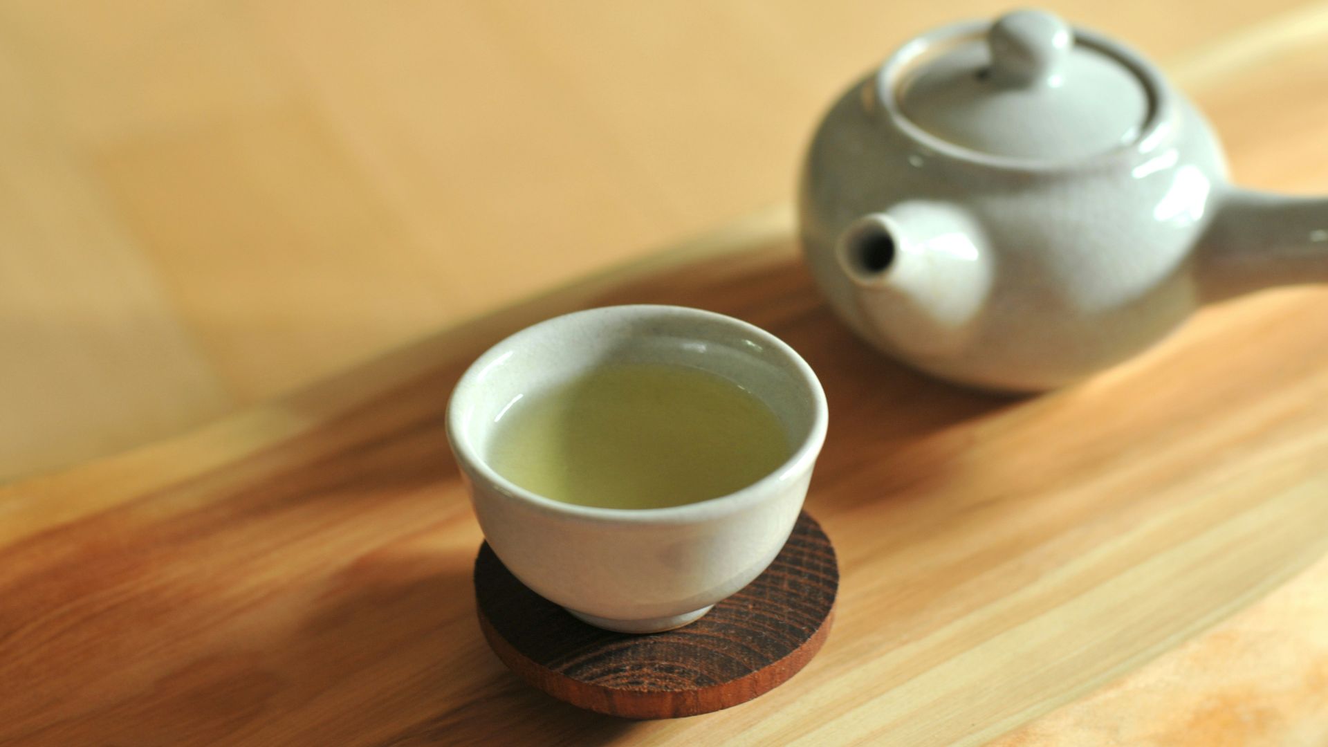 white ceramic teacup on brown wooden table