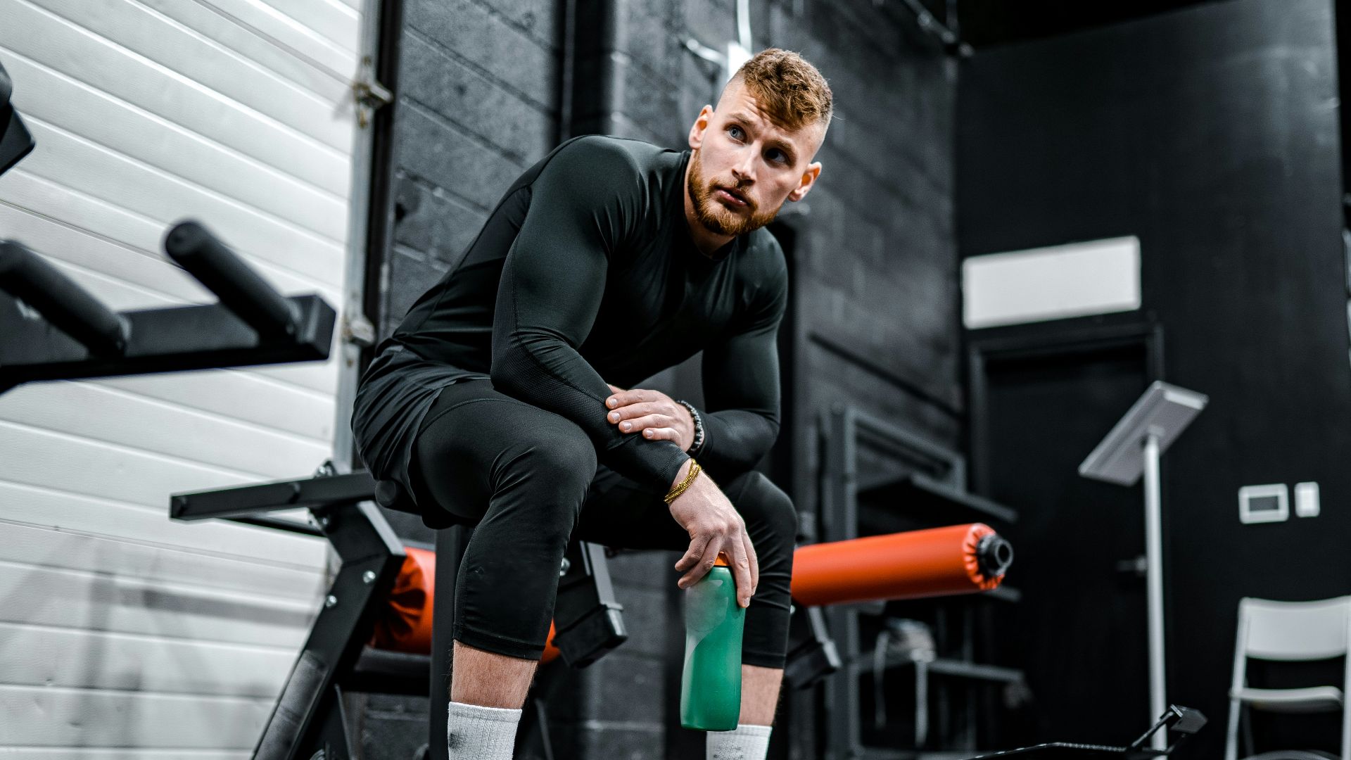 woman in black long sleeve shirt and black pants sitting on exercise equipment