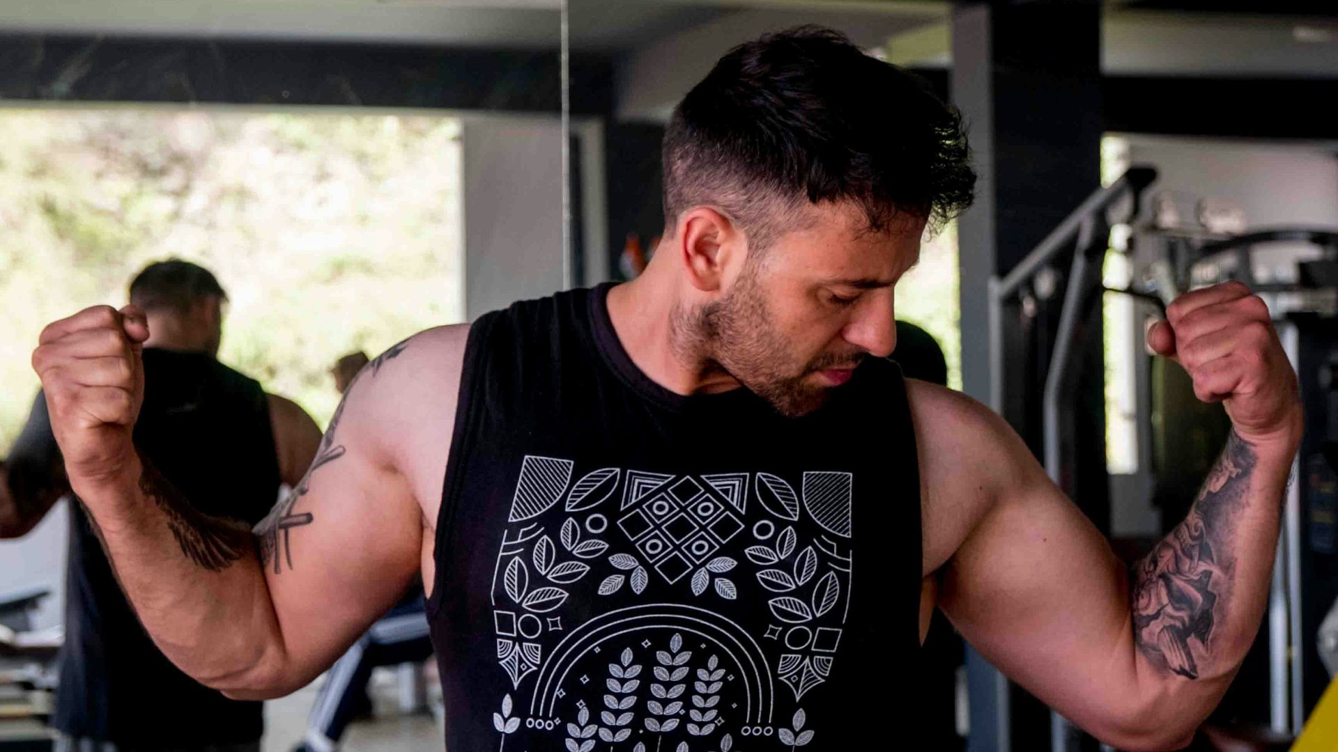 a man with a tattoo on his arm holding a barbell