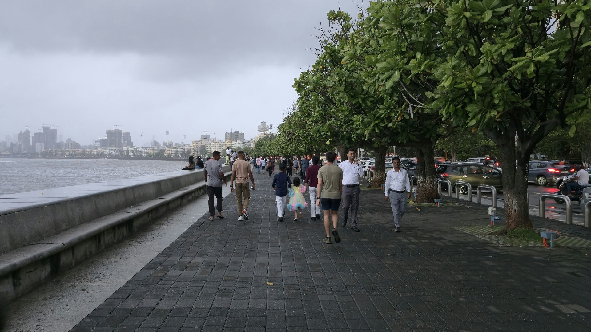 People are walking along a seaside promenade.