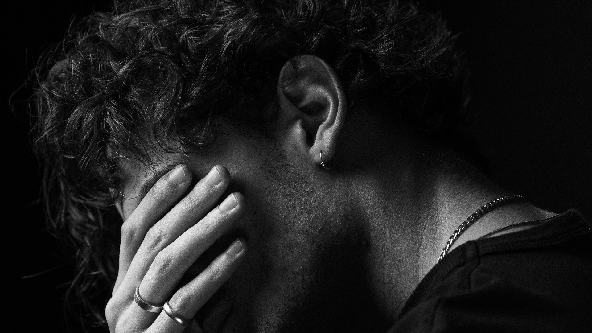 a black and white photo of a man covering his face