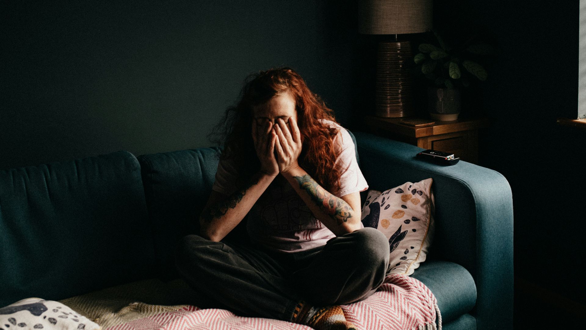 woman in black and white floral shirt sitting on black couch