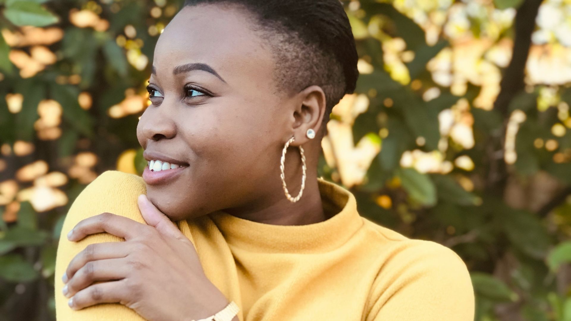 woman in yellow shirt holding yellow fruit