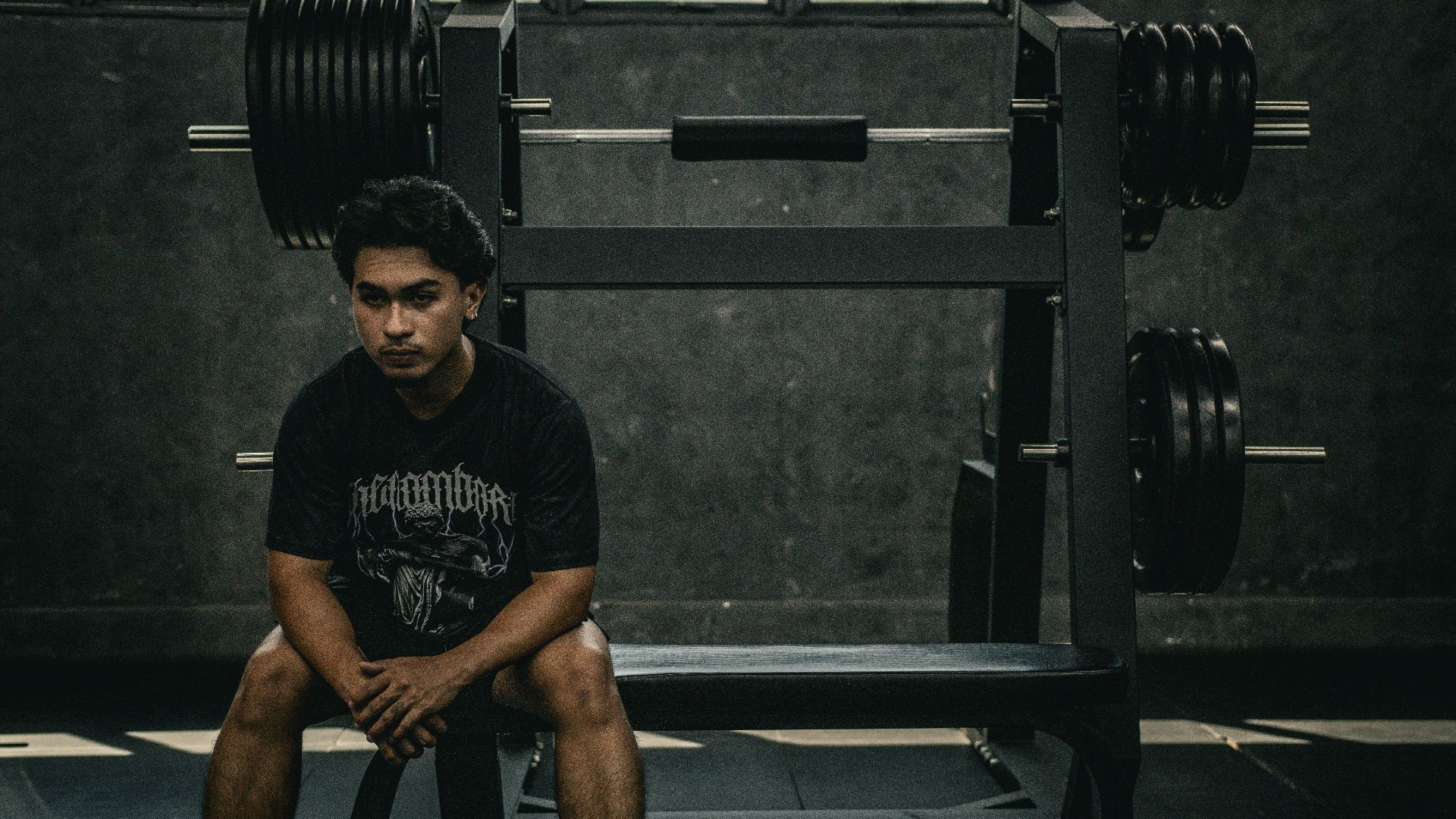 A man sitting on a bench in a gym