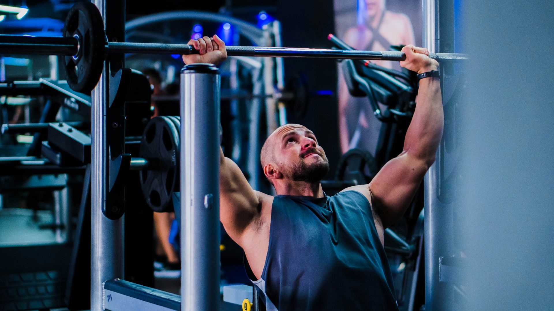 a man doing a pull up on a bar in a gym