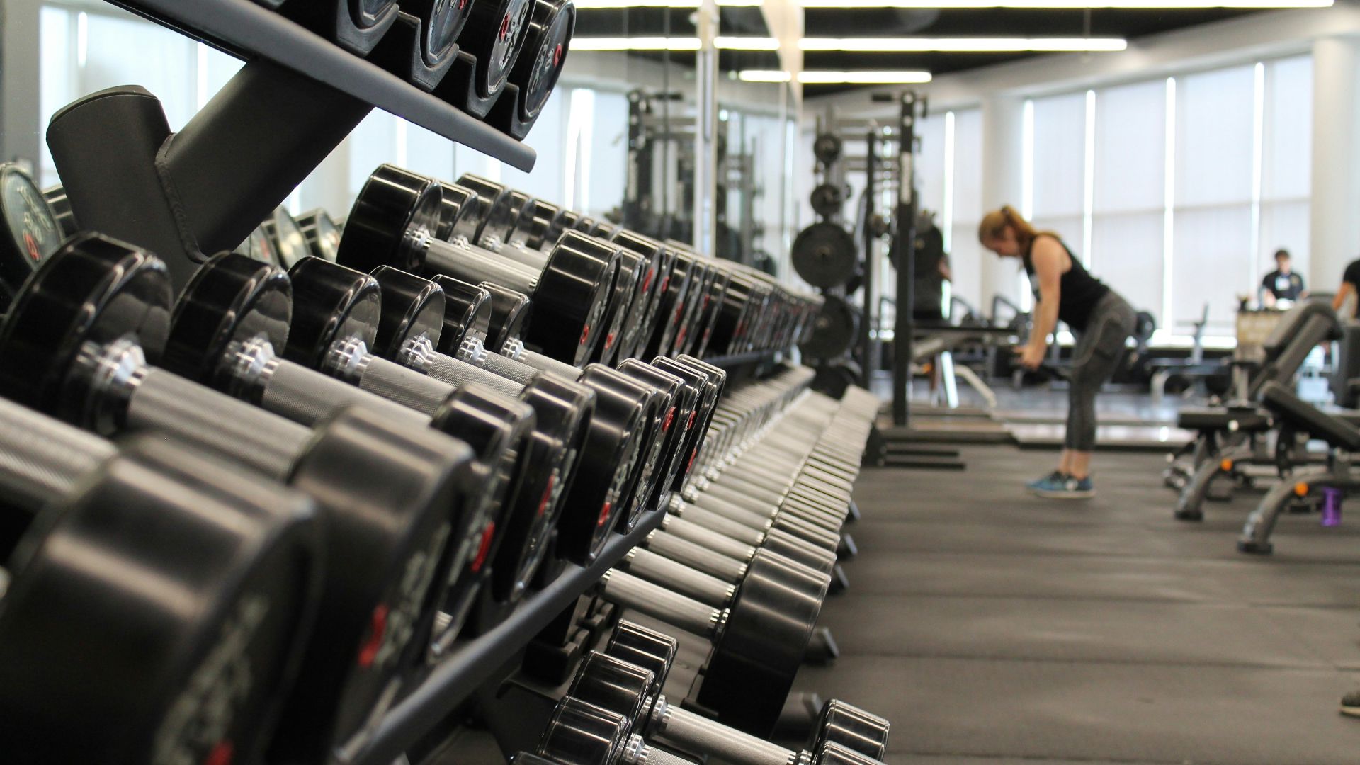 woman standing surrounded by exercise equipment