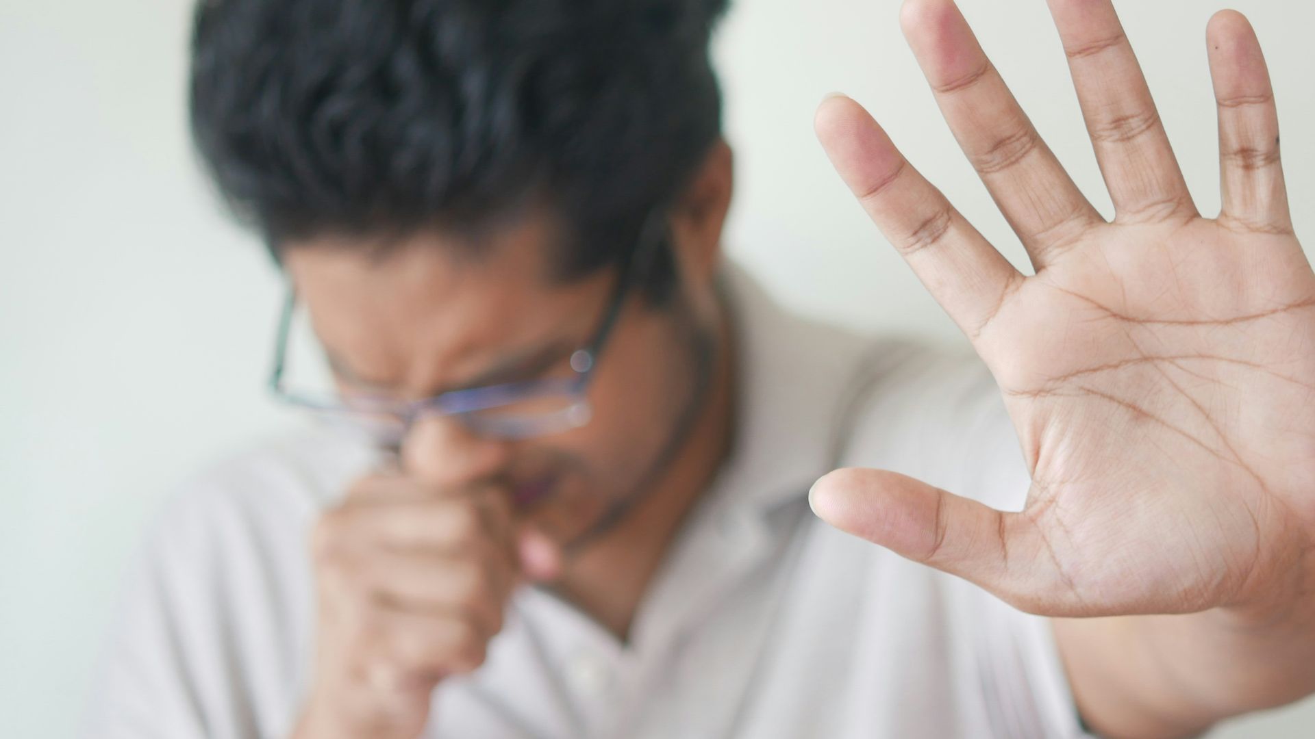 a man holding his hand up in front of his face