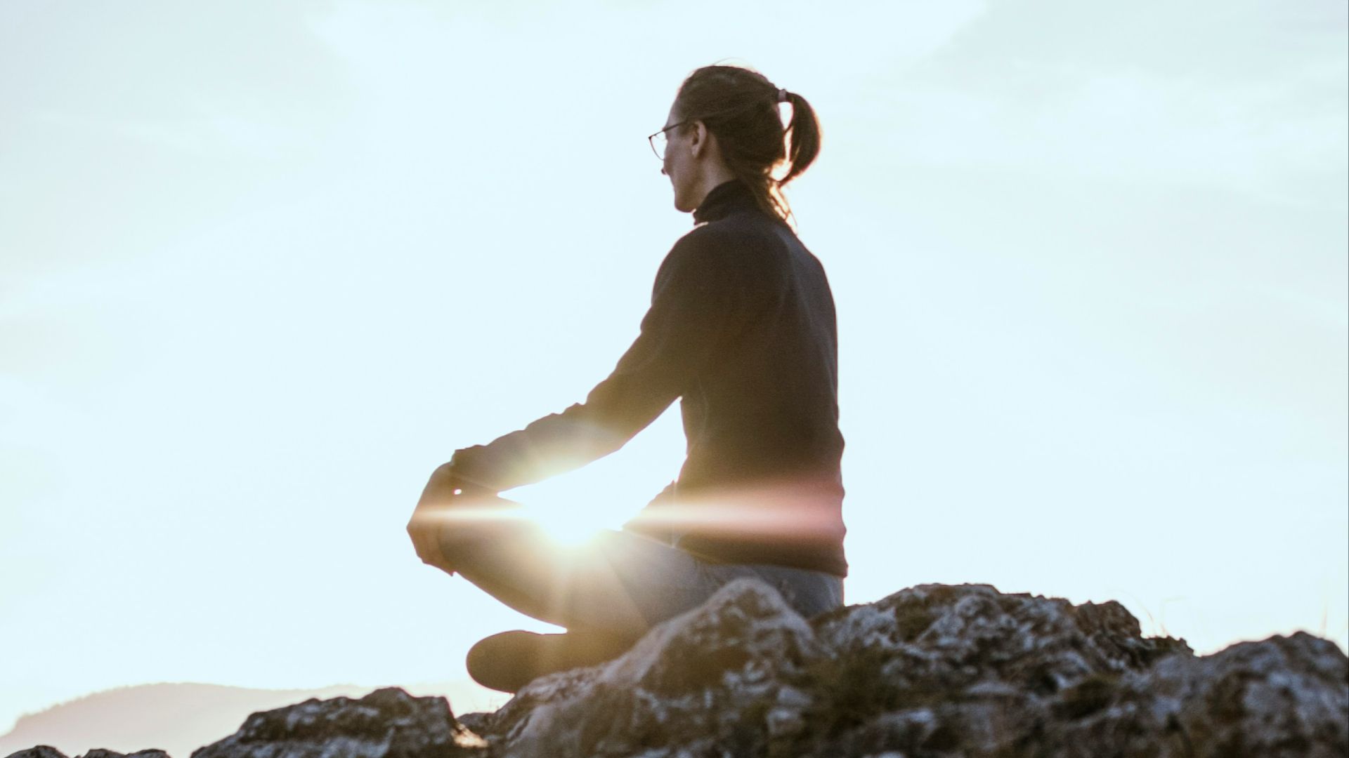person sitting on rock formation during daytime
