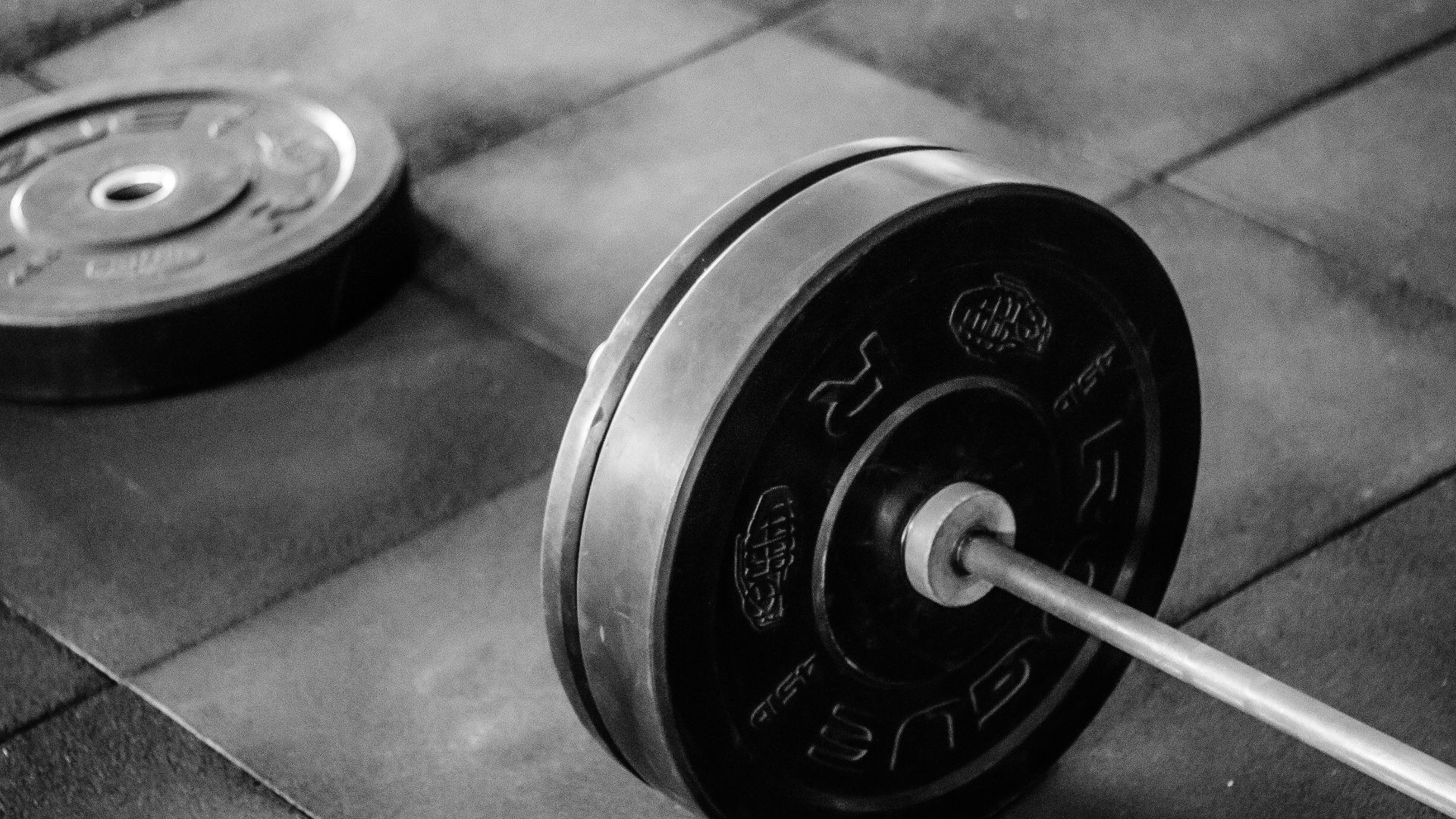 black barbell on tile flooring