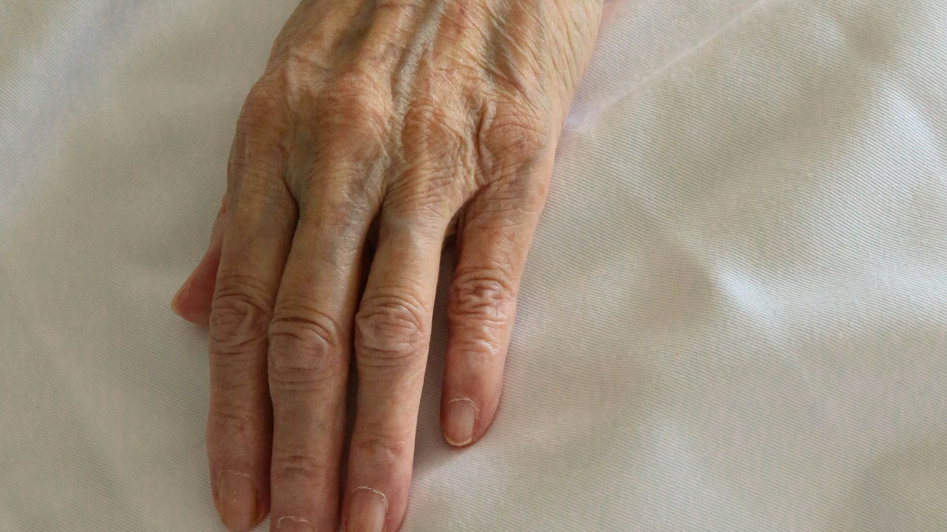 persons left hand on white textile
