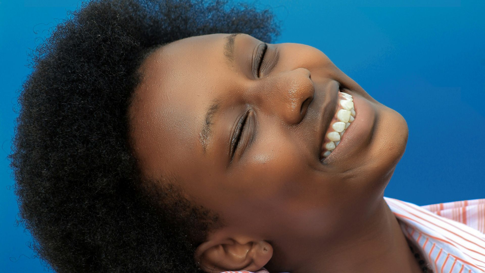smiling girl in pink and white stripe shirt