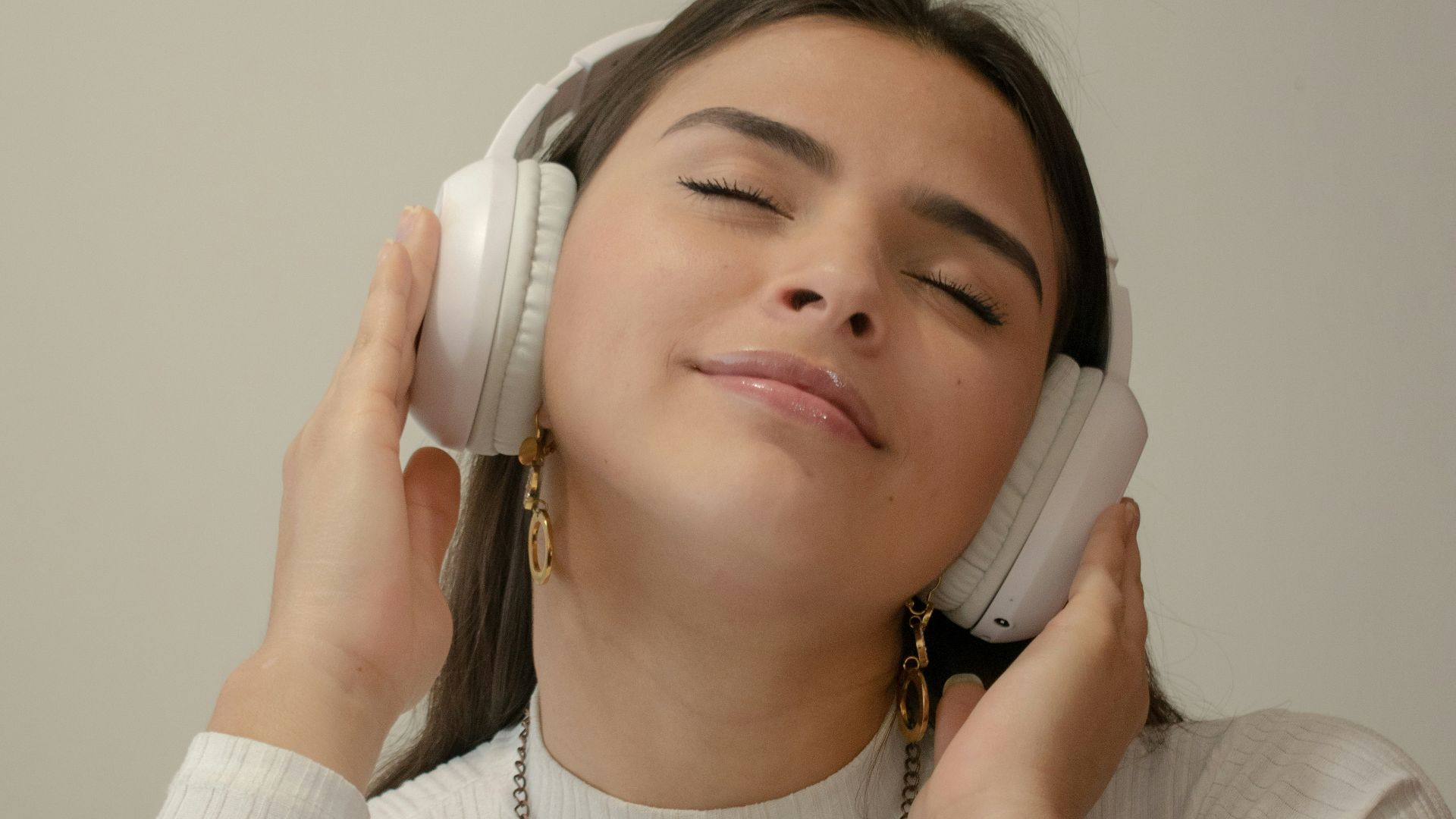a woman with her eyes closed holding a phone to her ear