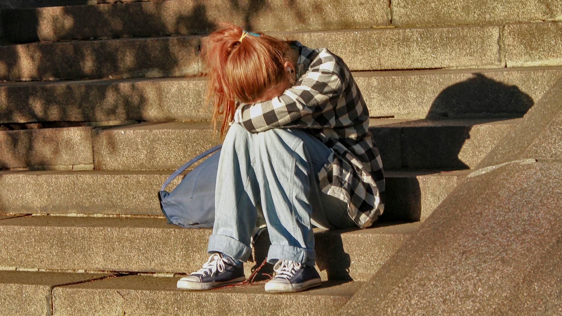 woman in black and white dress sitting on concrete stairs