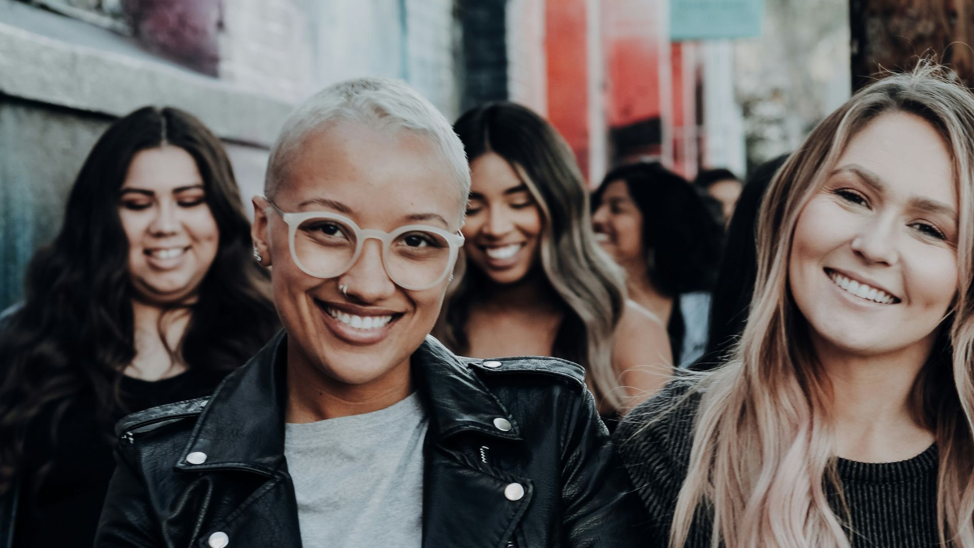 man in black leather jacket beside woman in black and white stripe shirt