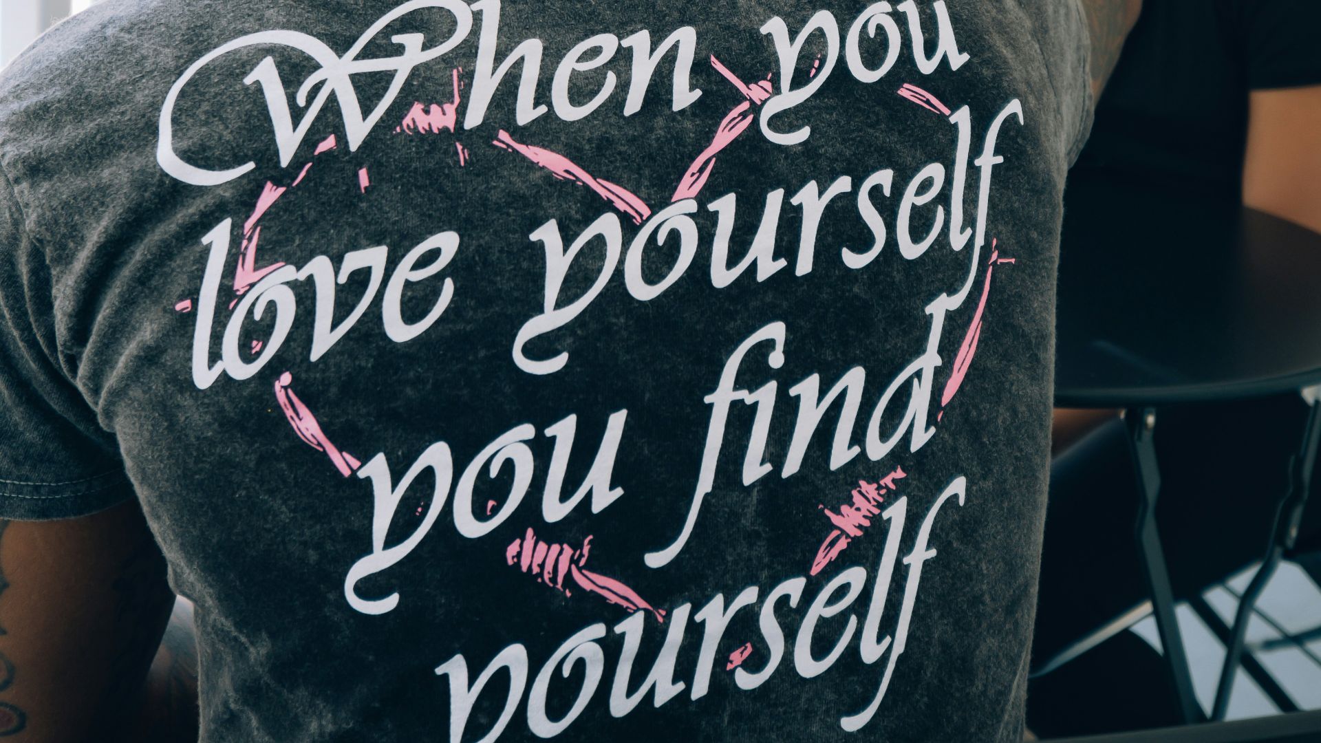 man in gray crew neck t-shirt sitting beside woman in black shirt