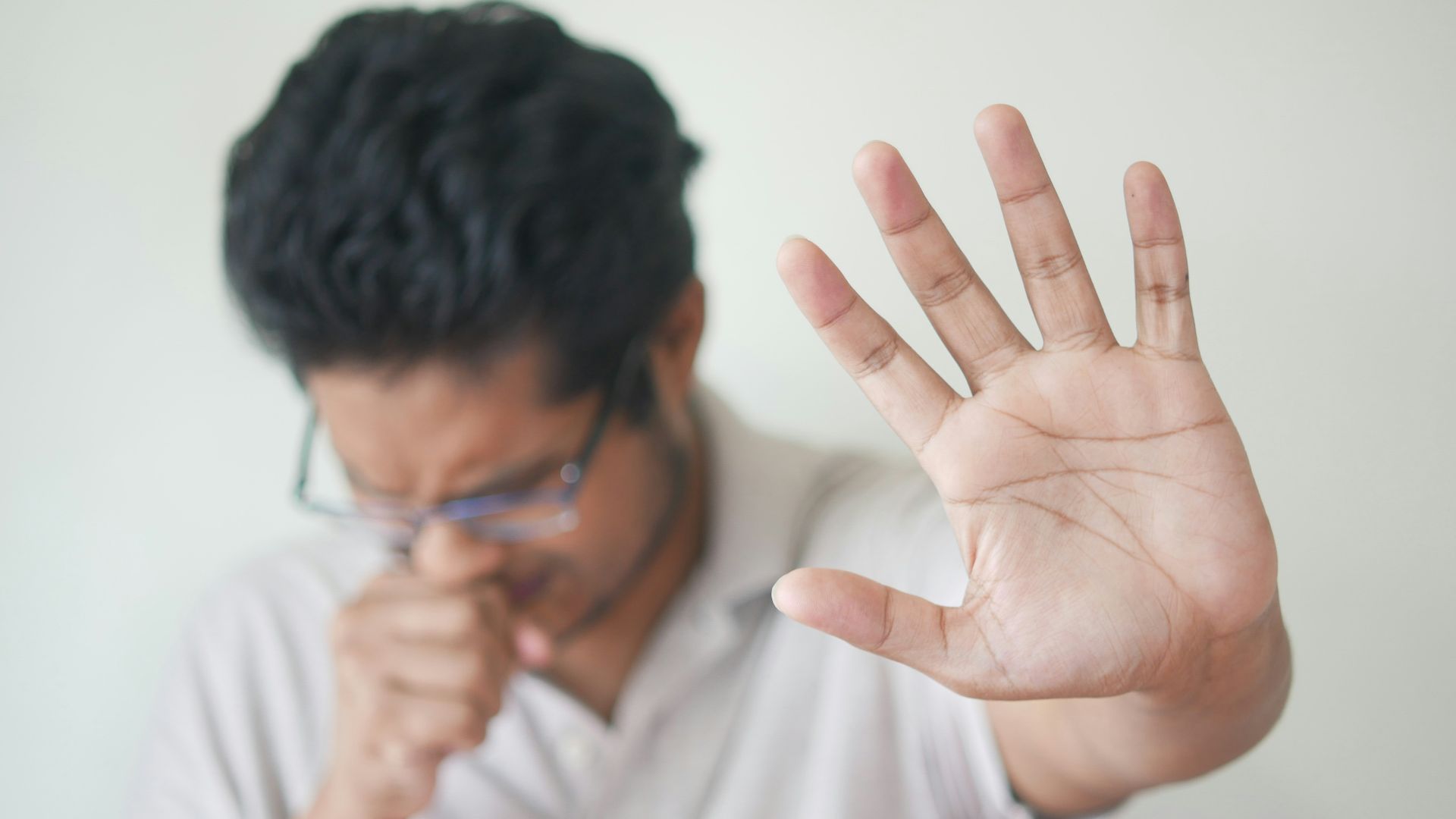 a man holding his hand up in front of his face