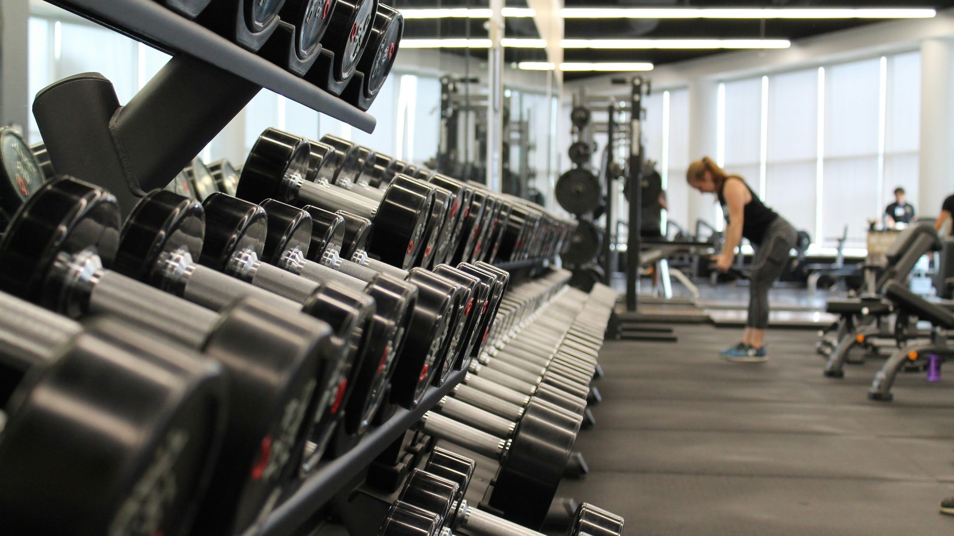woman standing surrounded by exercise equipment