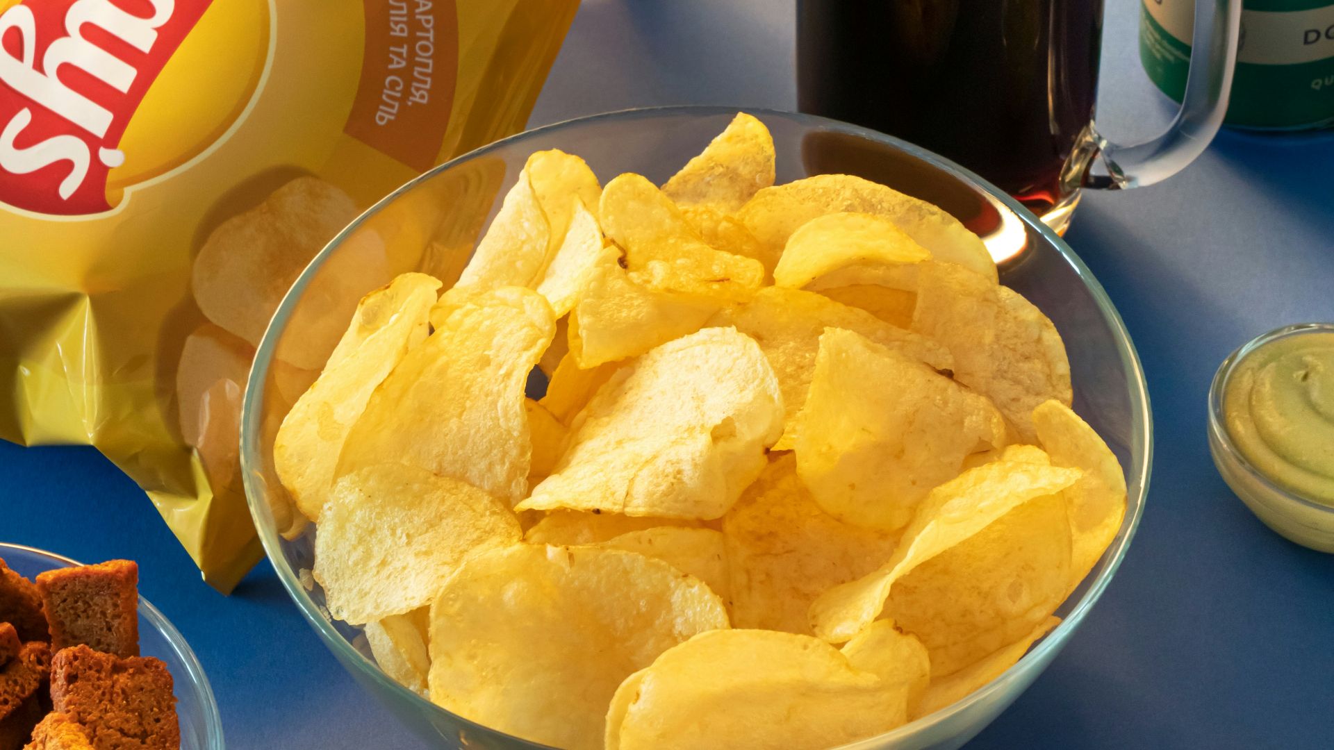 clear drinking glass beside brown bread on blue ceramic plate