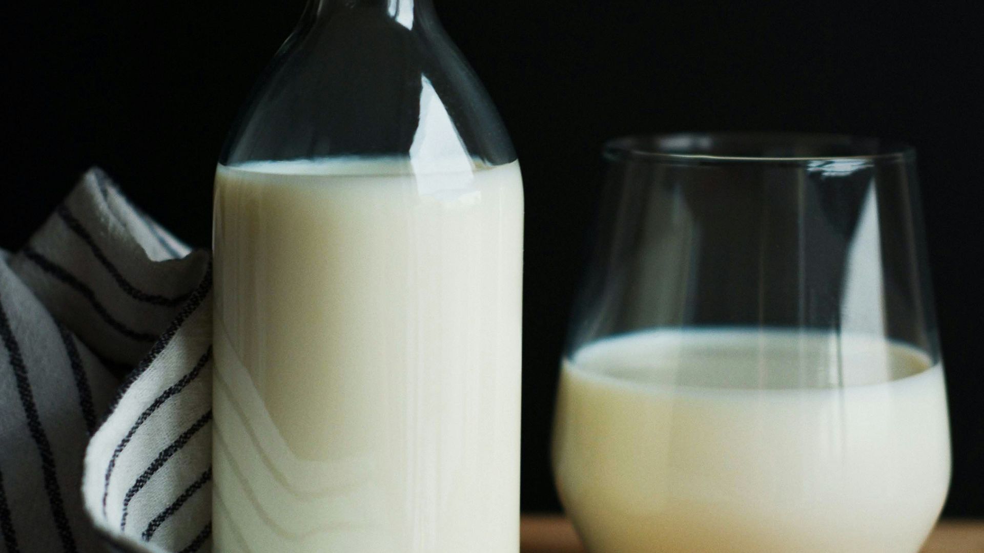 a bottle of milk next to a glass of milk