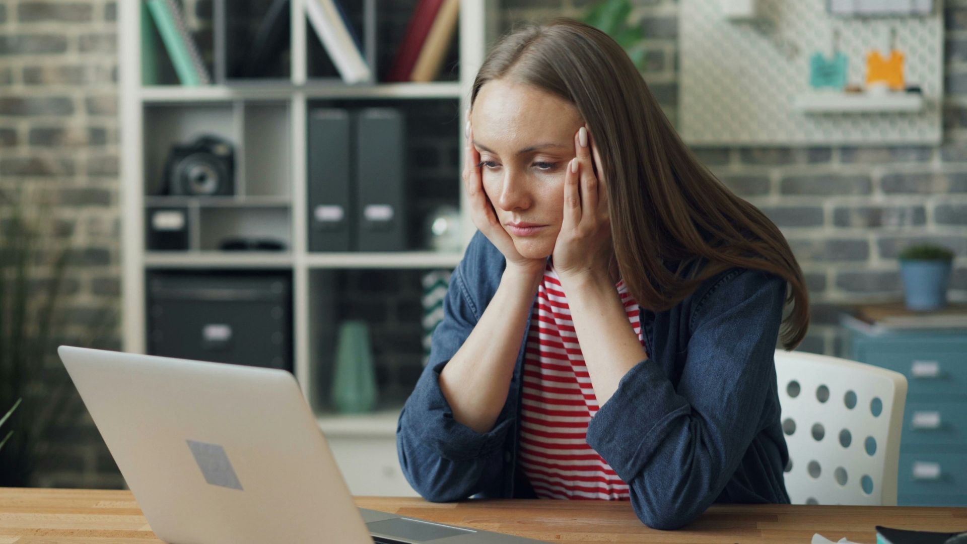 a woman sitting at a table with a laptop in front of her