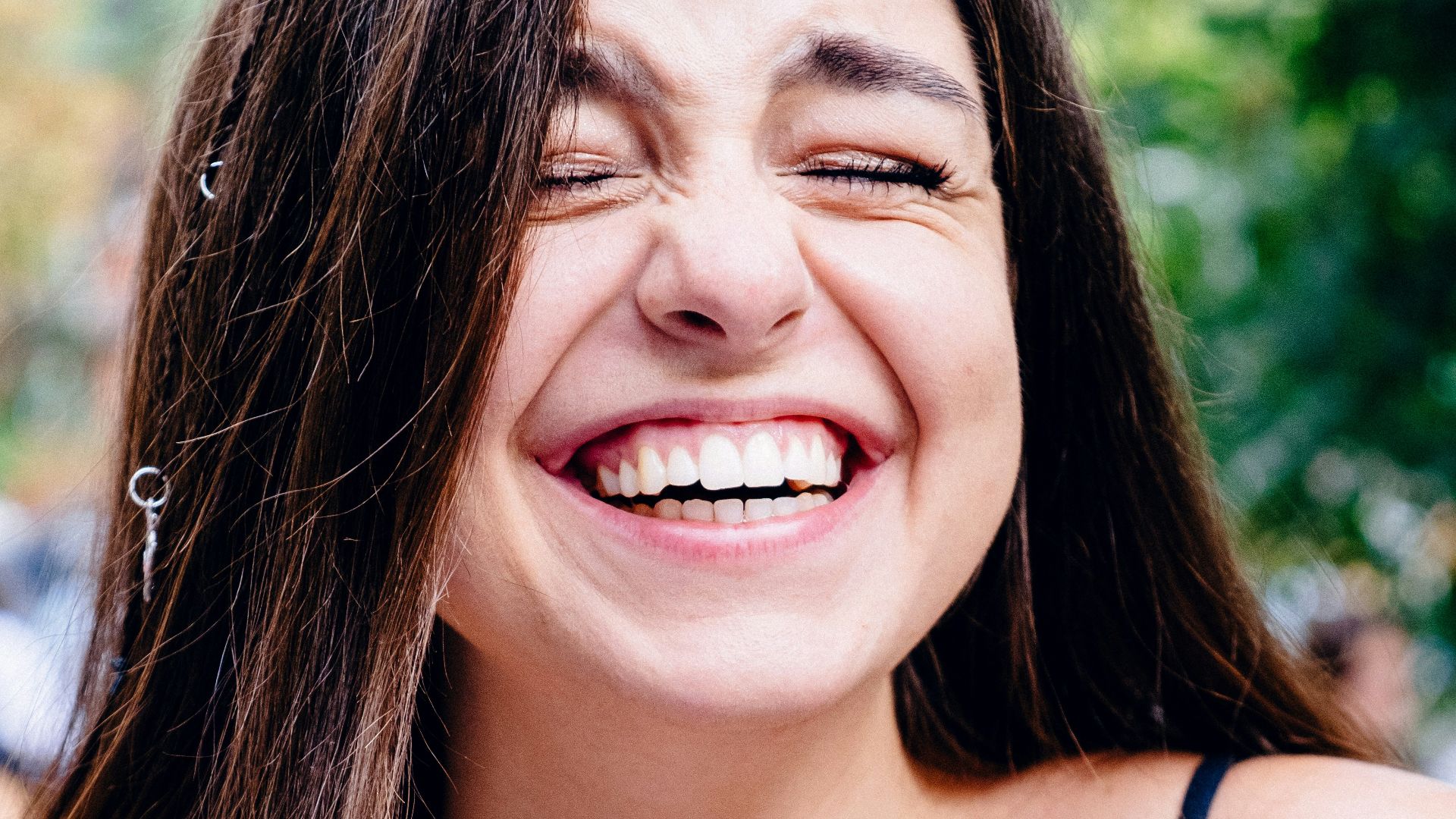 woman in black spaghetti strap top smiling