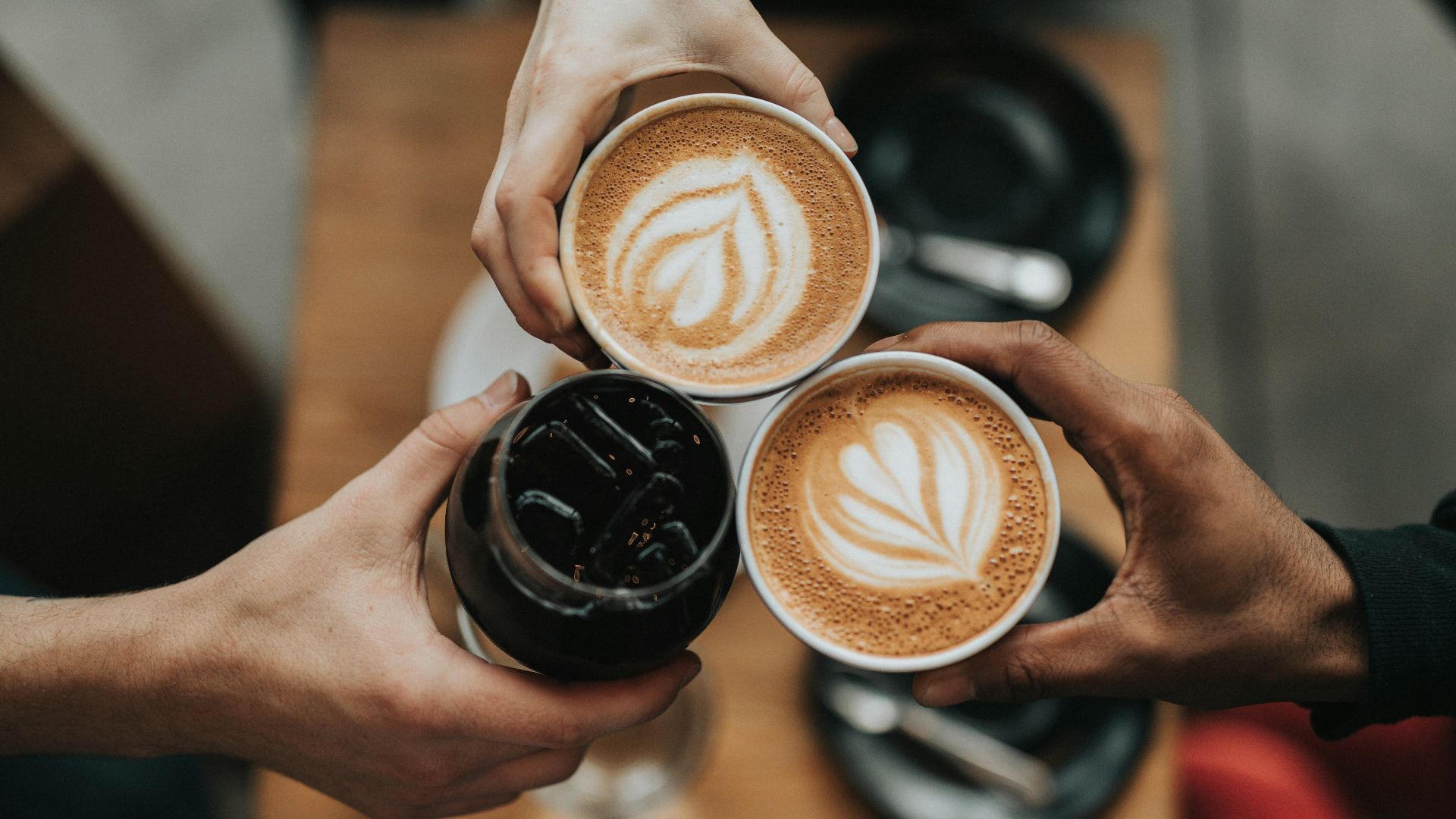 three person holding beverage cups