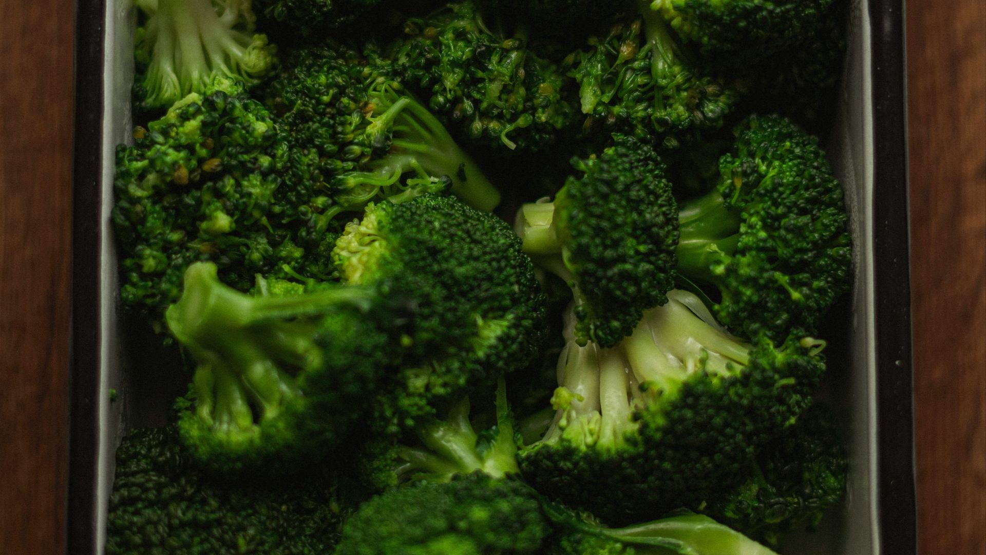 a dish of broccoli on a wooden table