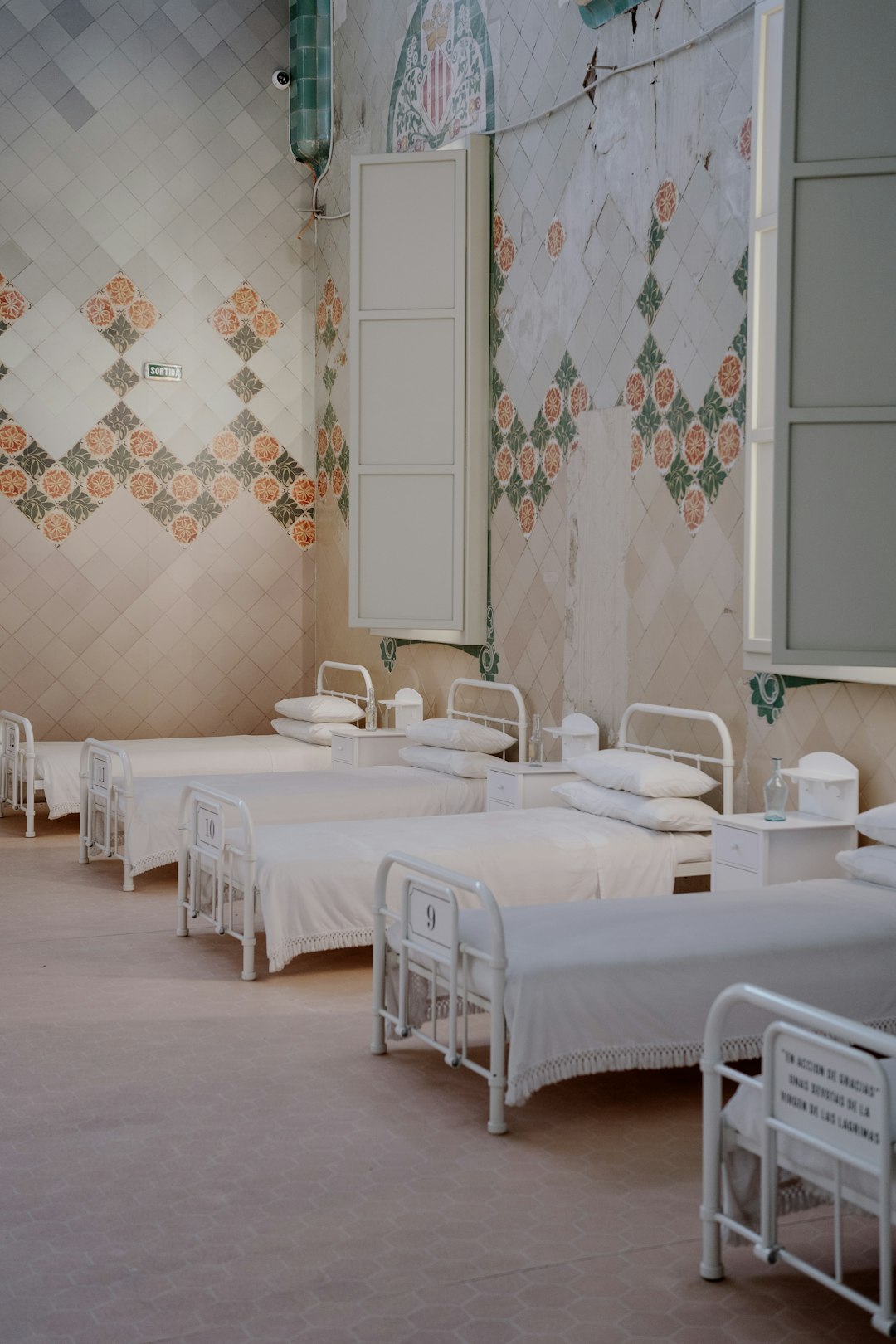 a row of beds in a room with tiled walls