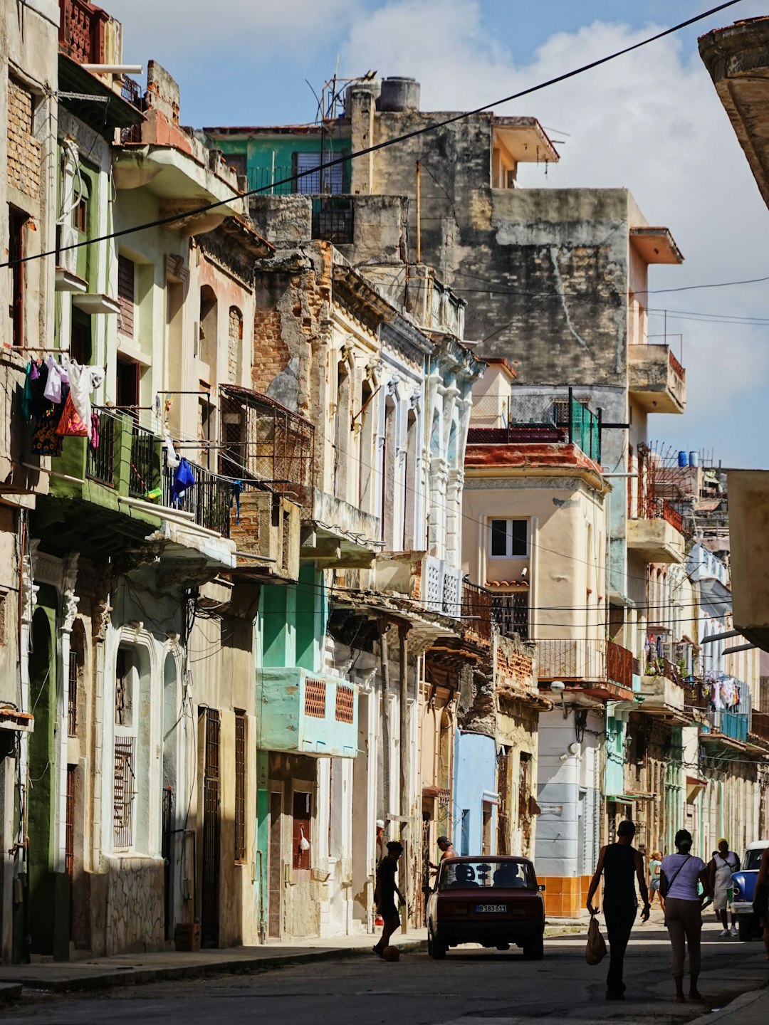 A couple of people walking down a street next to tall buildings