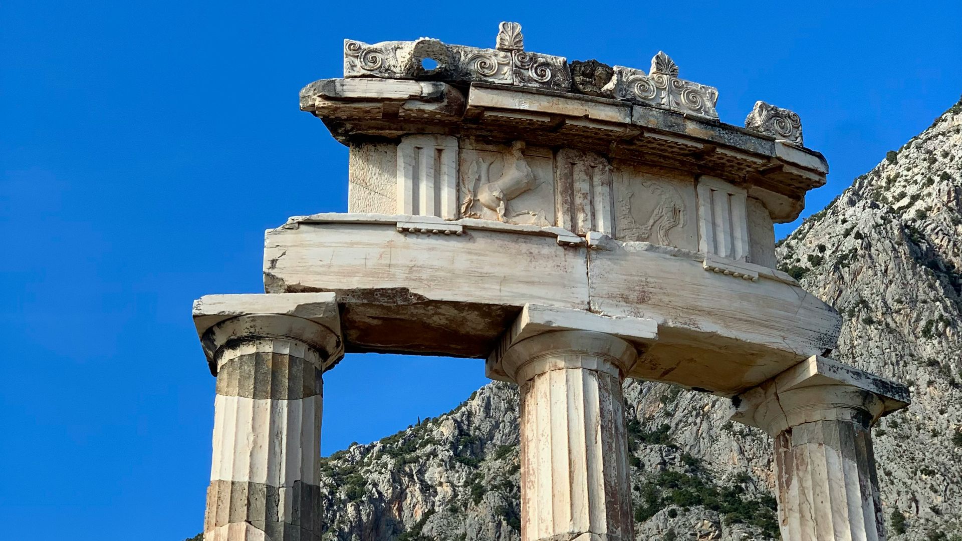 a stone structure in front of a mountain