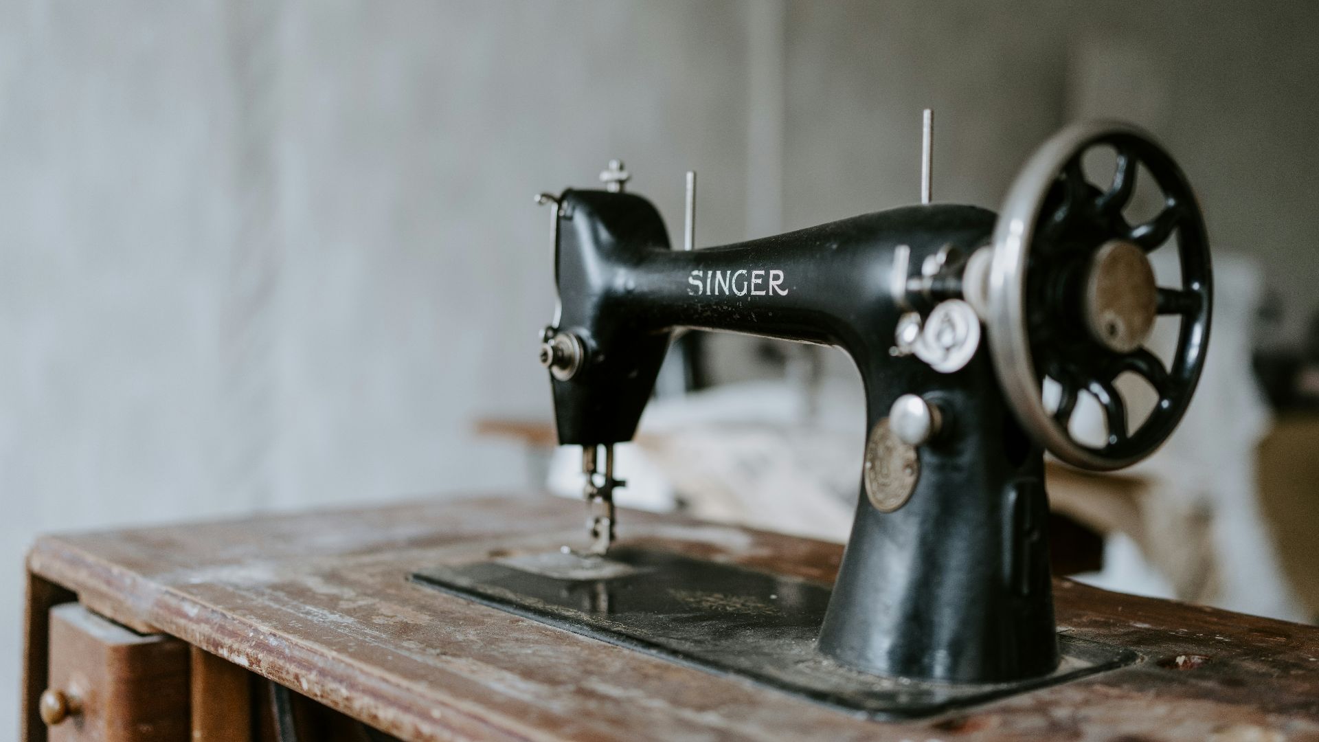 black sewing machine on brown wooden table