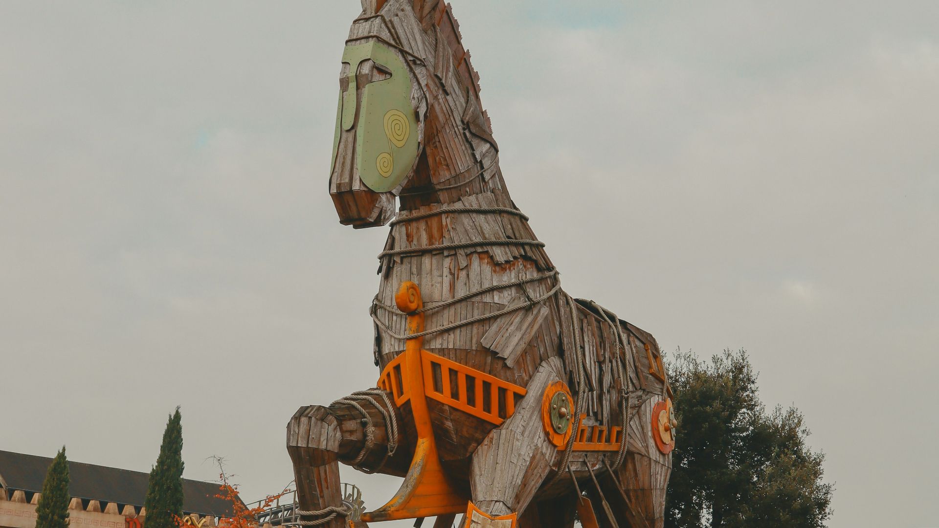 a large wooden horse statue sitting on top of a dirt field