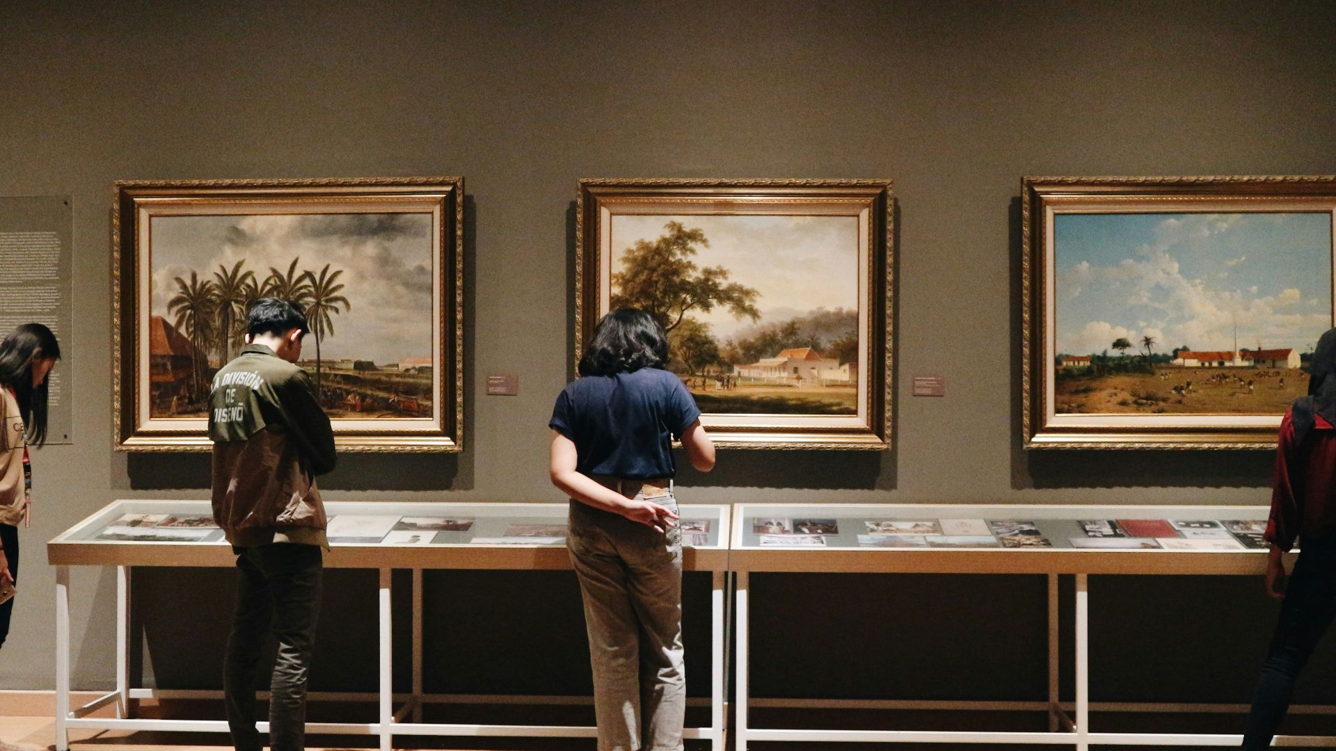 people standing in front of paintings