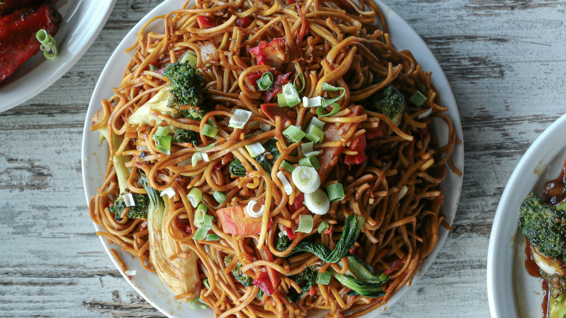 three plates of food on a wooden table