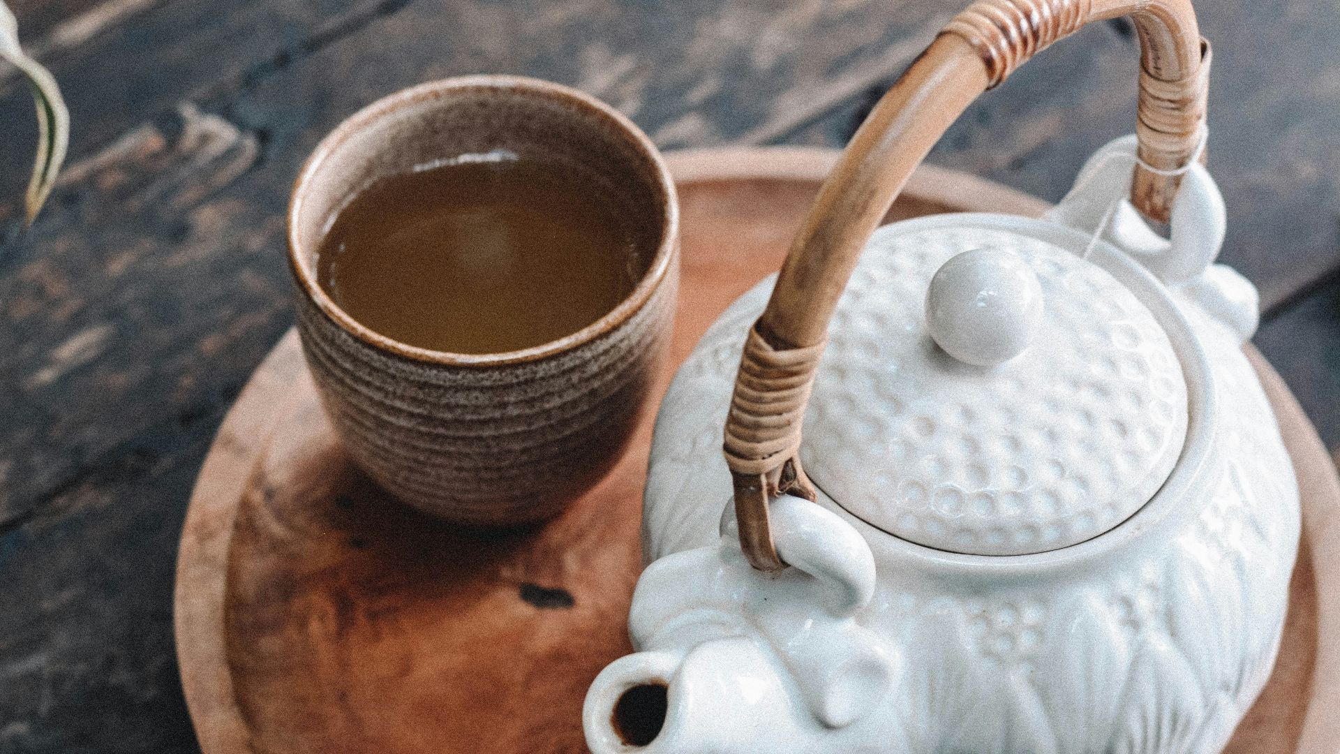 white and brown ceramic teapot on wooden tray