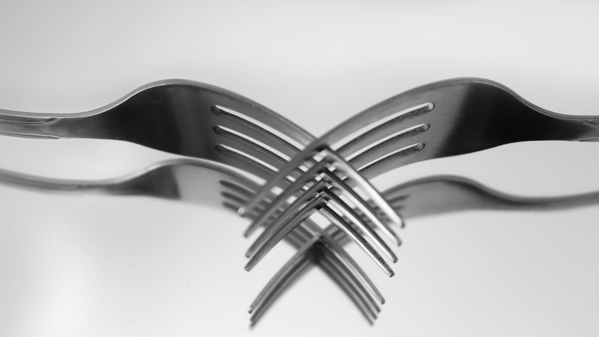 a black and white photo of forks in the air