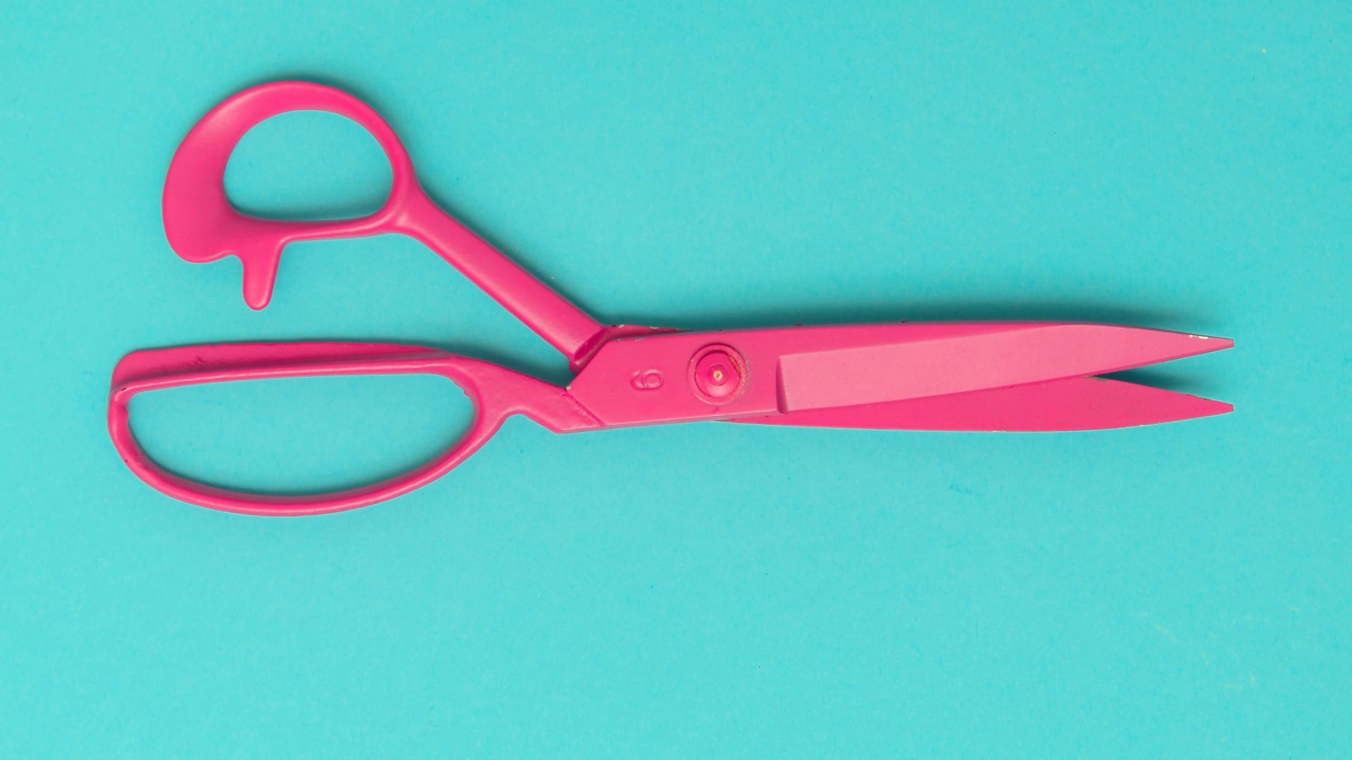 red handled scissors on blue surface
