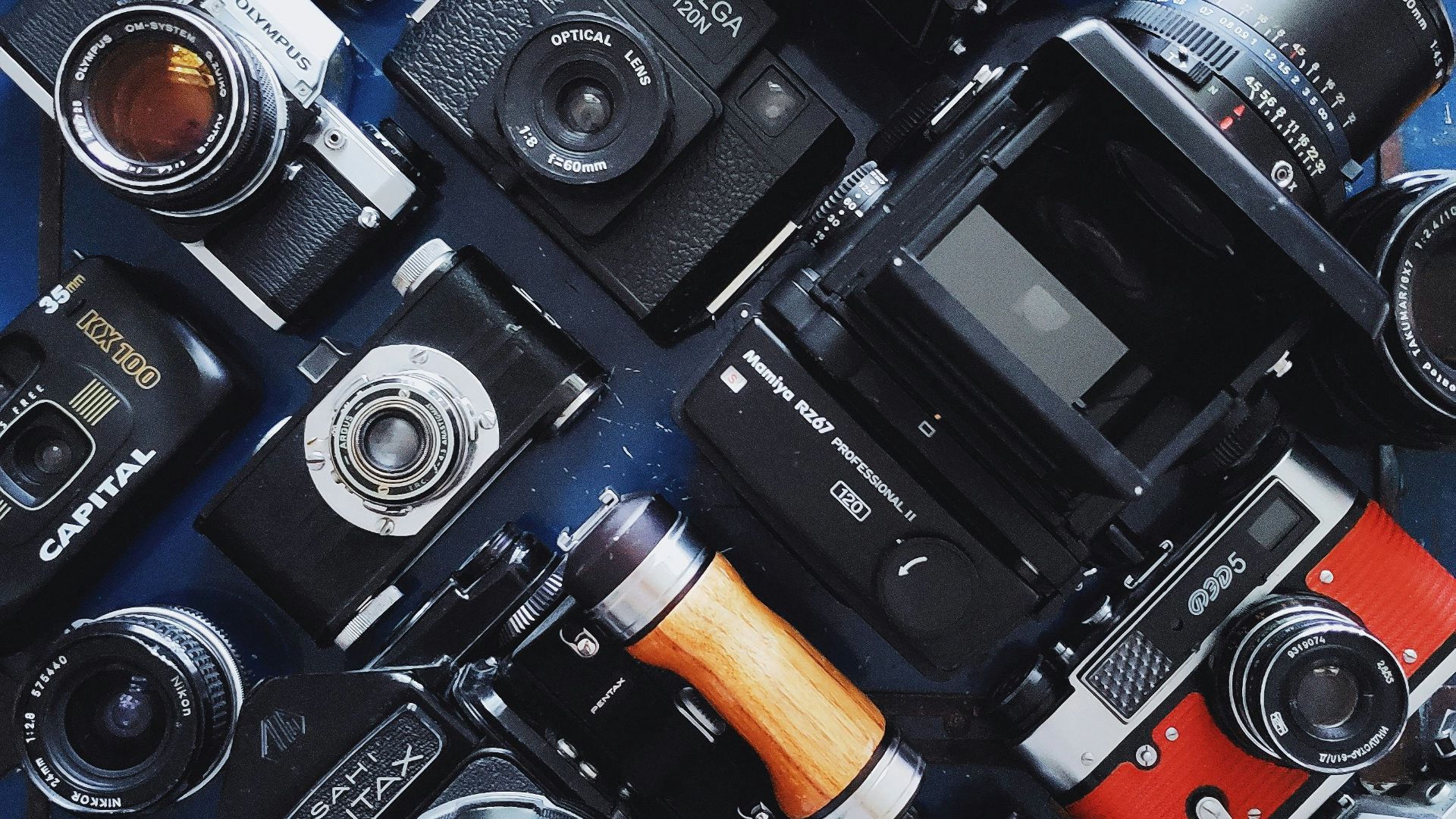 a table topped with lots of different types of cameras
