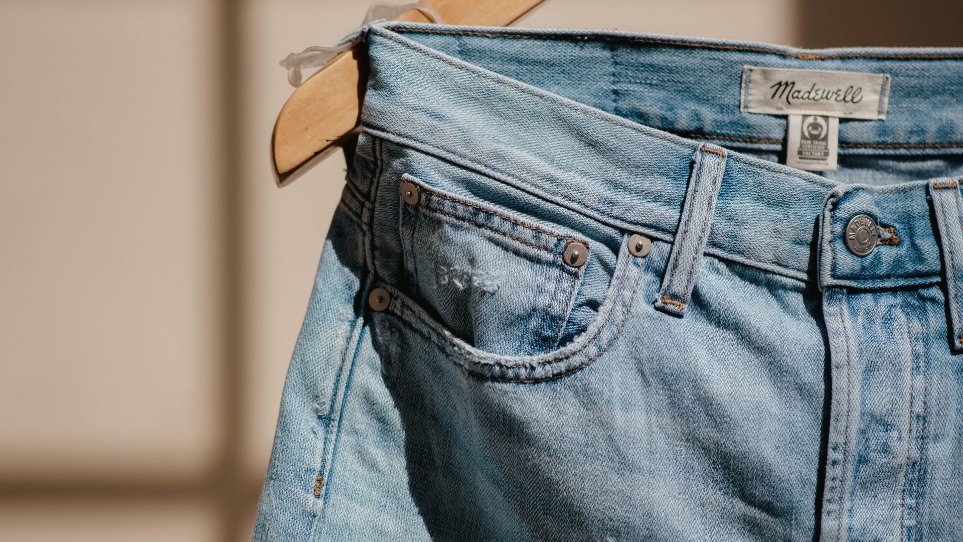 blue denim jeans on brown clothes hanger