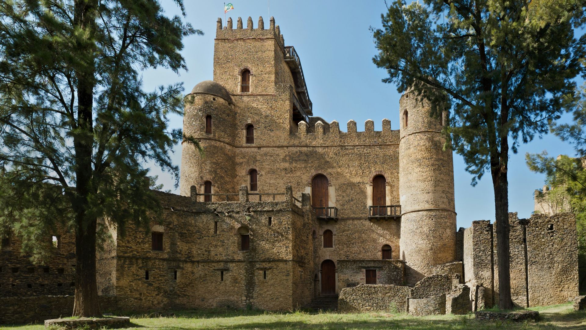 brown concrete building near green trees during daytime