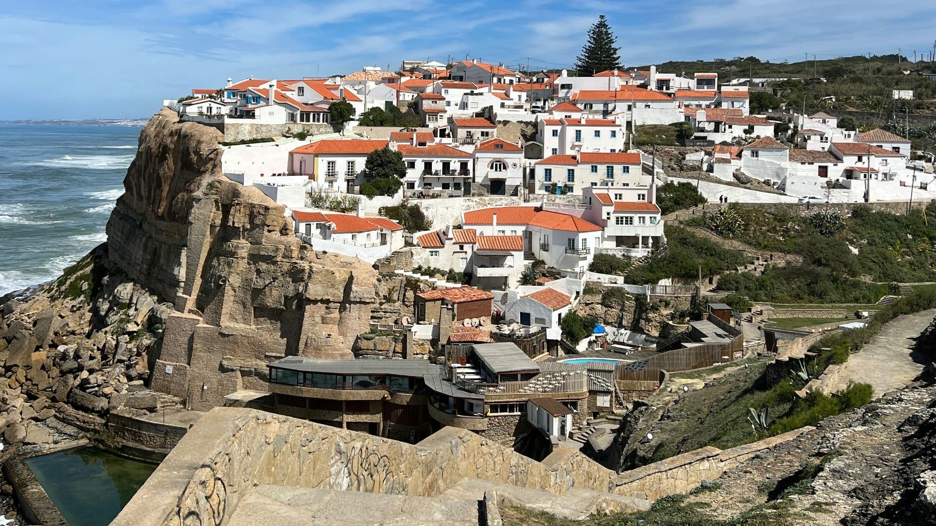 a scenic view of a small town on a cliff