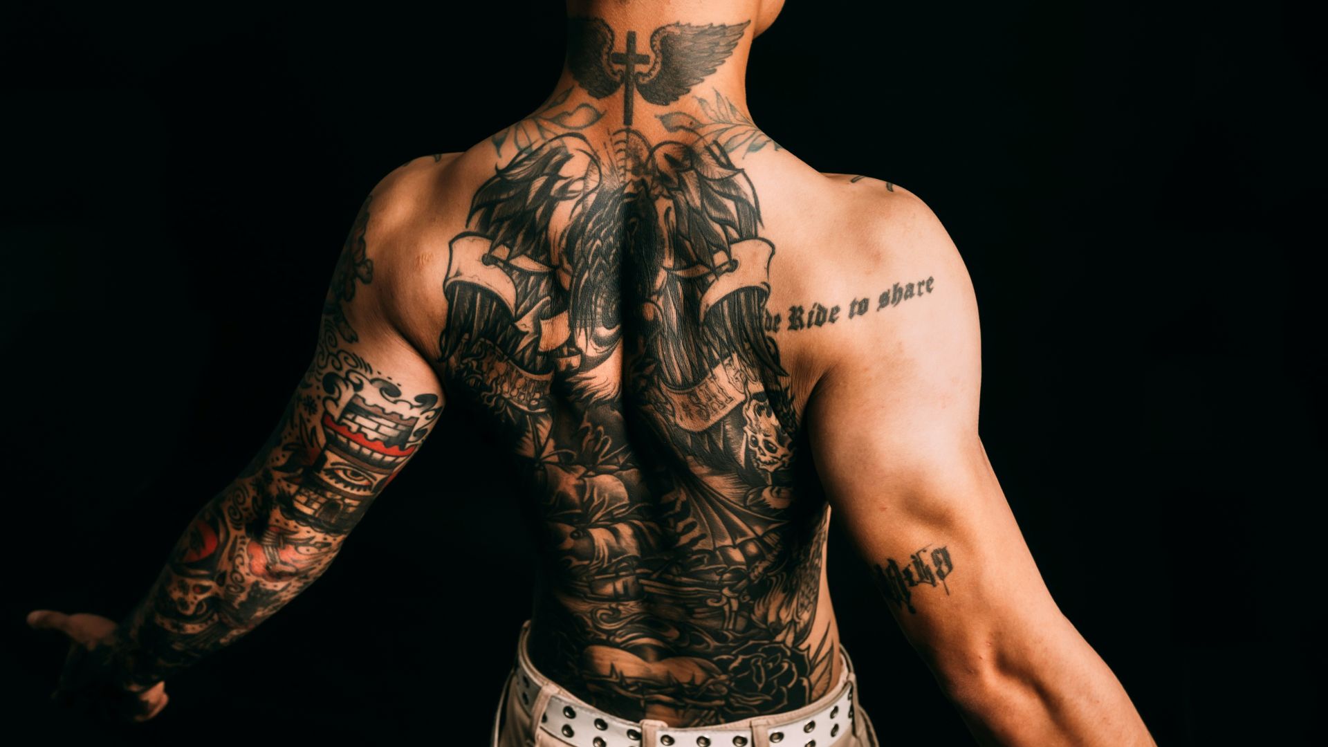 Man with elaborate full back and arm tattoos