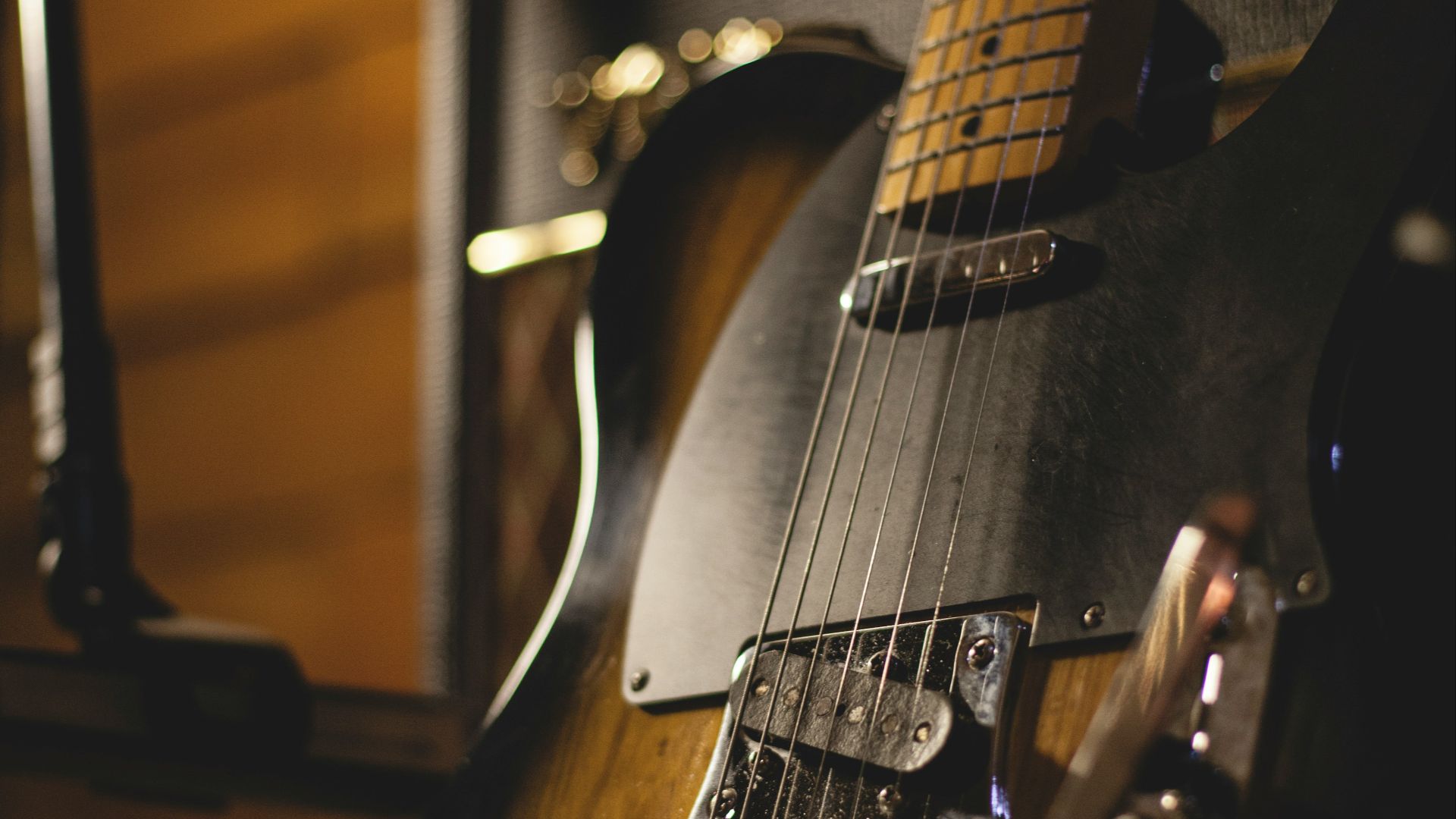 shallow focus photo of black and brown electric guitar