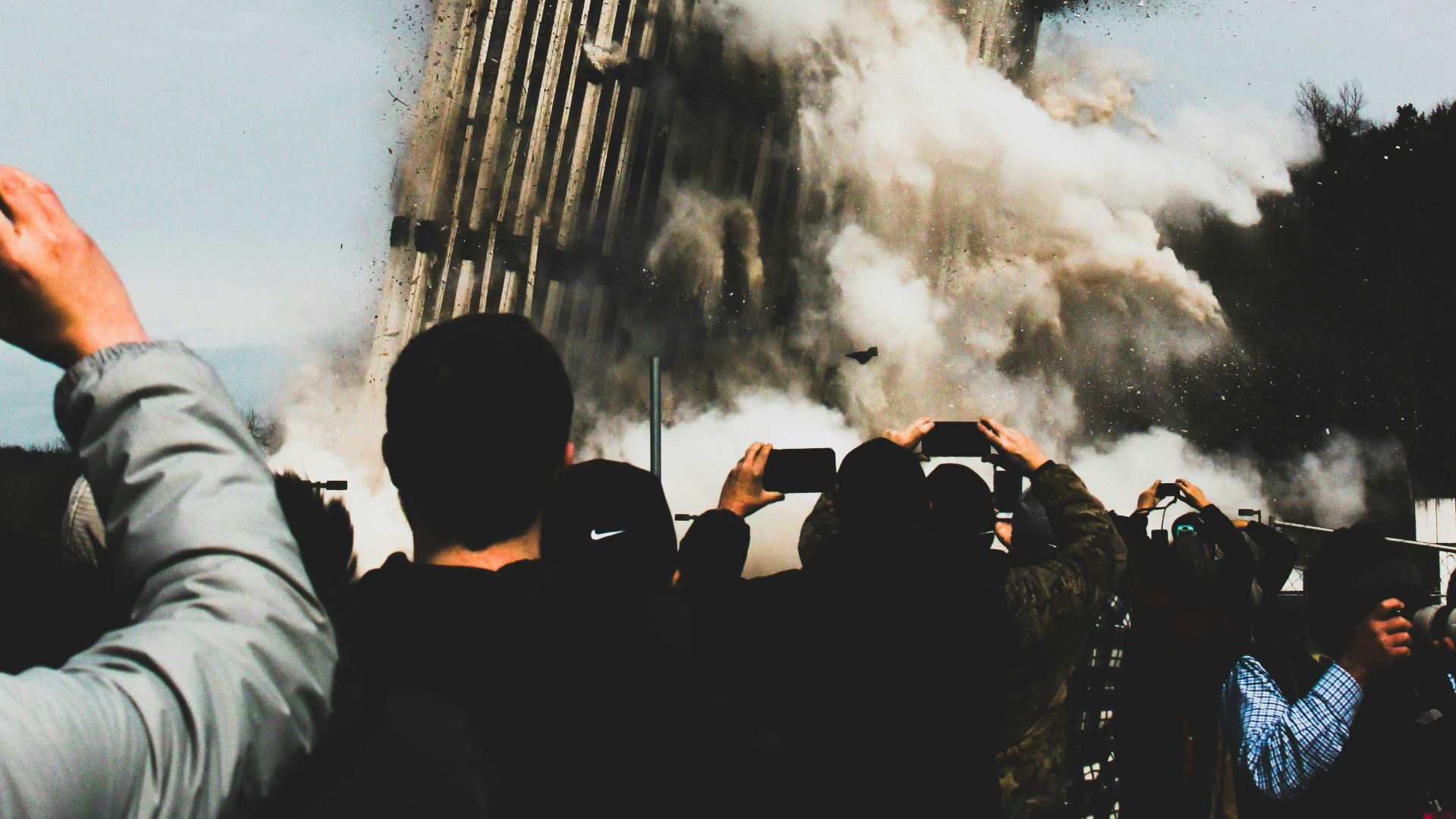 people taking photo of collapsing building