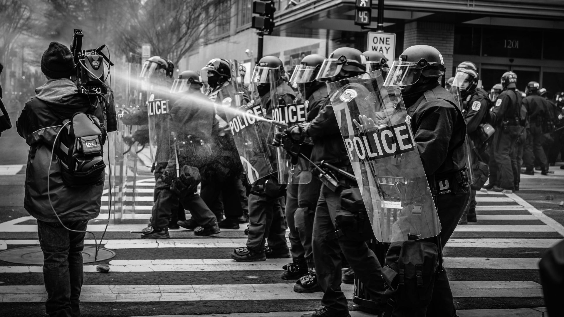 grayscale photo of police riot team on pedestrian lane